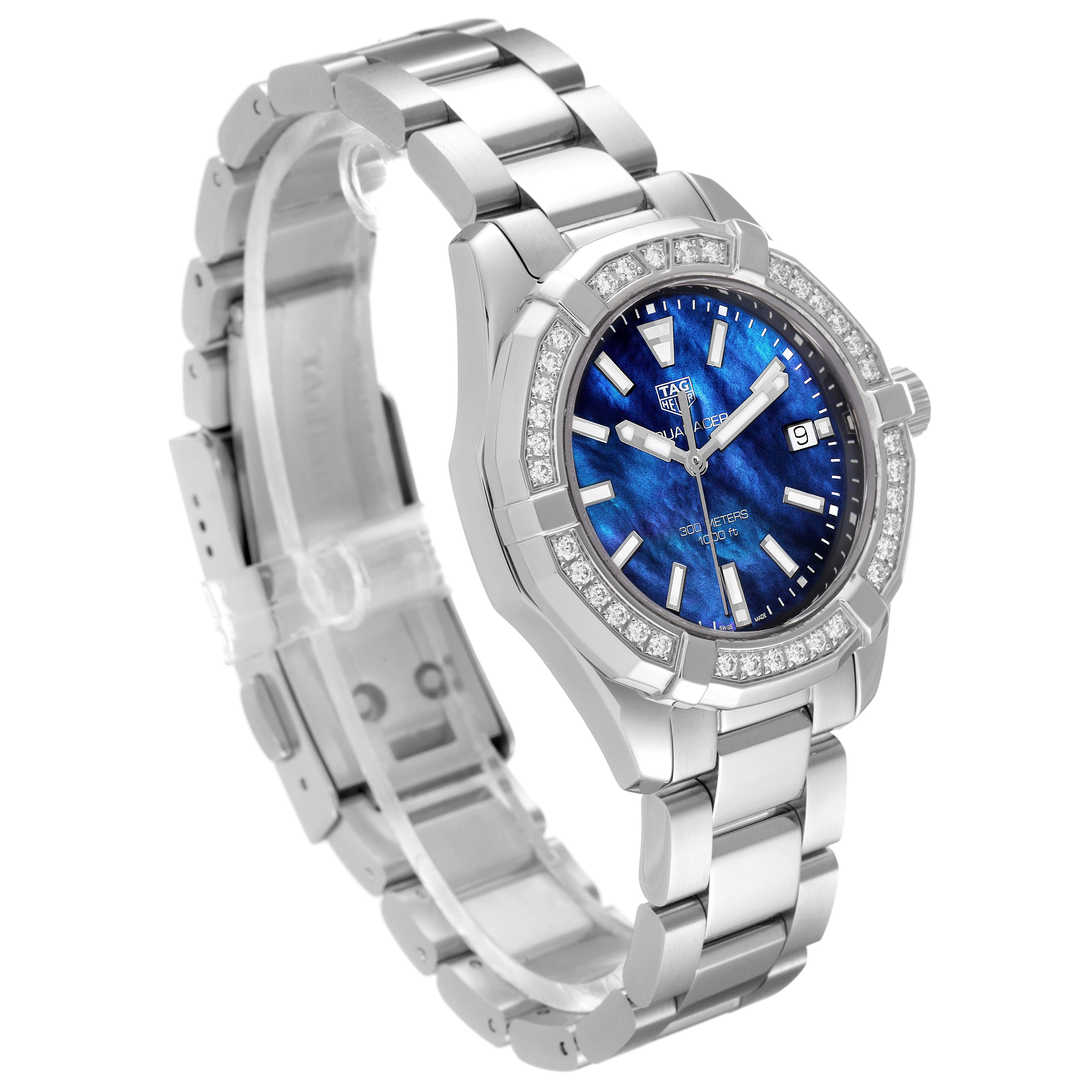 The image shows a Tag Heuer Aquaracer WAY1311 Women's Stainless Steel Mother of Pearl Dial WAY1311 Women's Stainless Steel Mother of Pearl Dial watch at an angle highlighting its silver bracelet, blue face, and diamond-encrusted bezel.