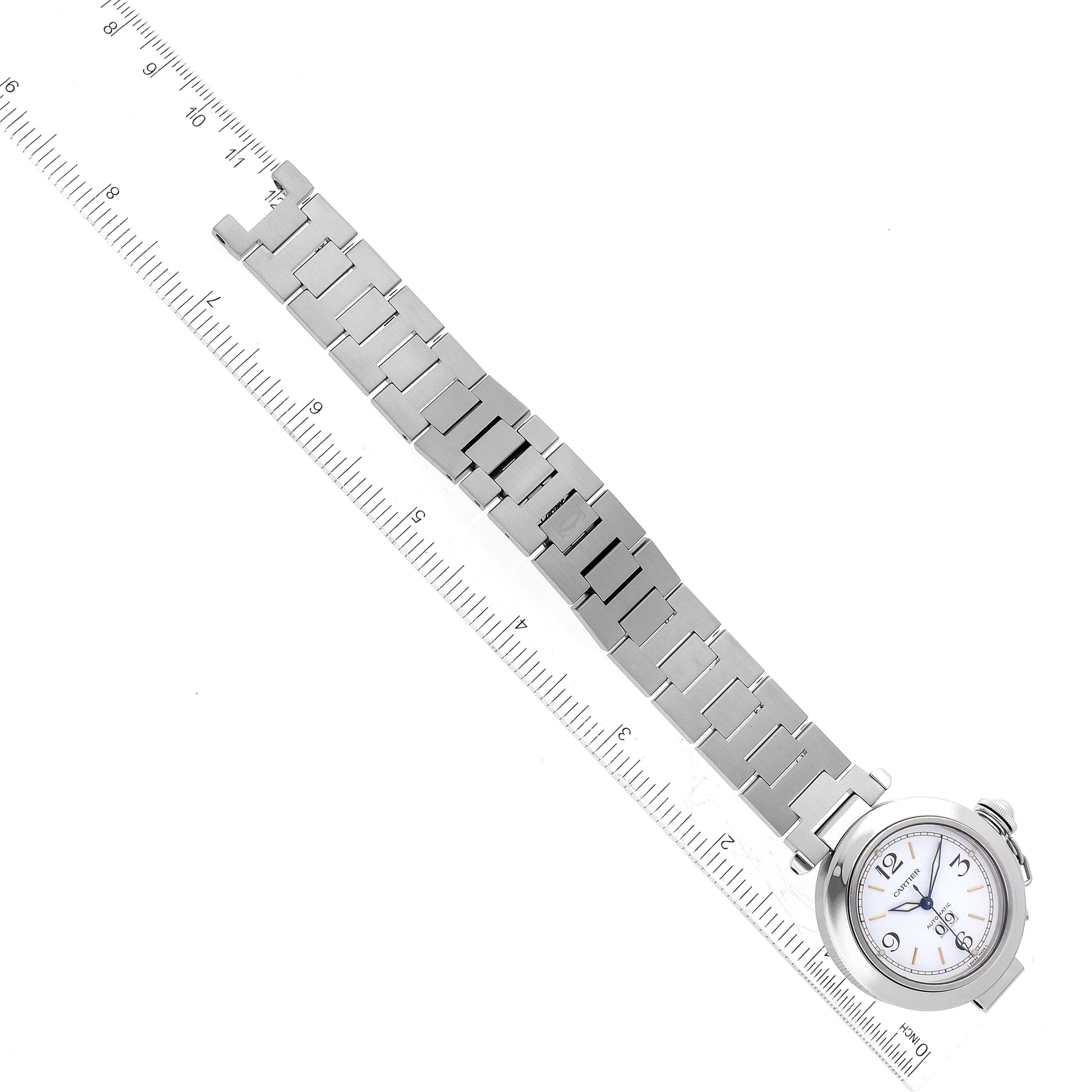 The image shows the face and metal bracelet of a Cartier Pasha W31044M7 Men's Stainless Steel White Dial W31044M7 Men's Stainless Steel White Dial watch laid next to a ruler for measurement.