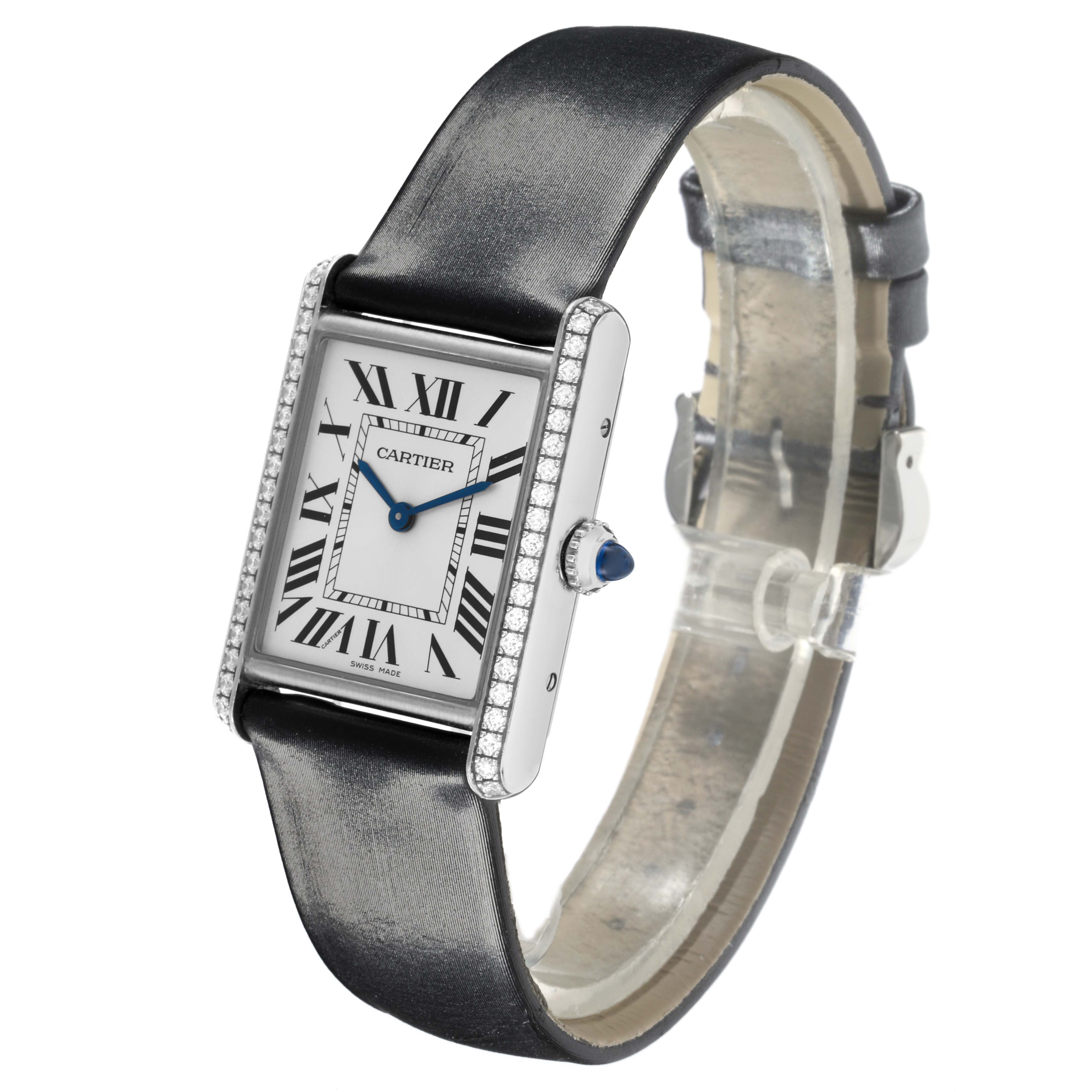 The Cartier Tank Must W4TA0017 Women
s Stainless Steel Silver Dial W4TA0017 Women
s Stainless Steel Silver Dial watch is shown at an angled side view, highlighting its face, strap, and bejeweled edges.