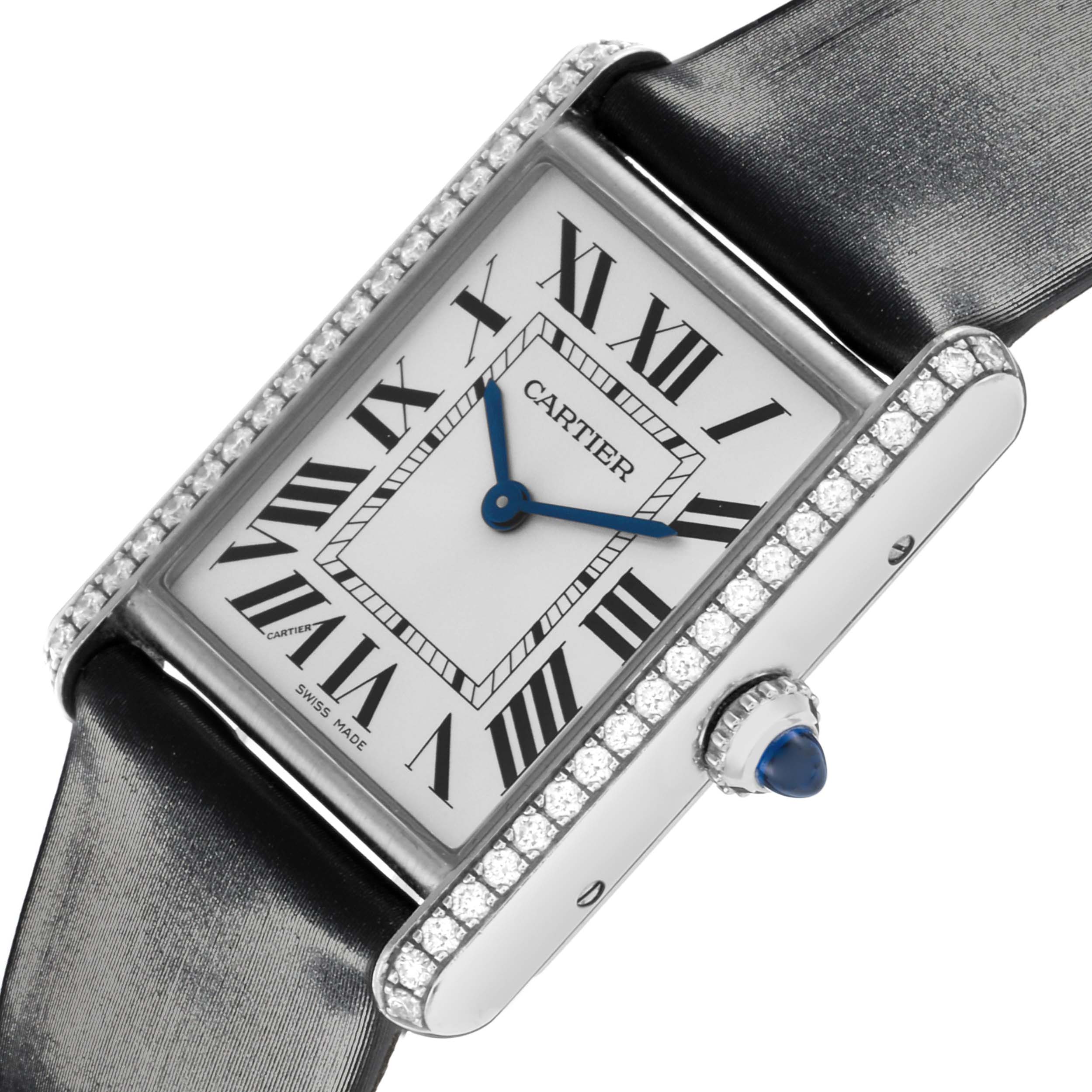 The Cartier Tank Must W4TA0017 Women
s Stainless Steel Silver Dial W4TA0017 Women
s Stainless Steel Silver Dial watch is shown at an angled close-up, highlighting its rectangular face, Roman numerals, blue hands, and jeweled bezel.