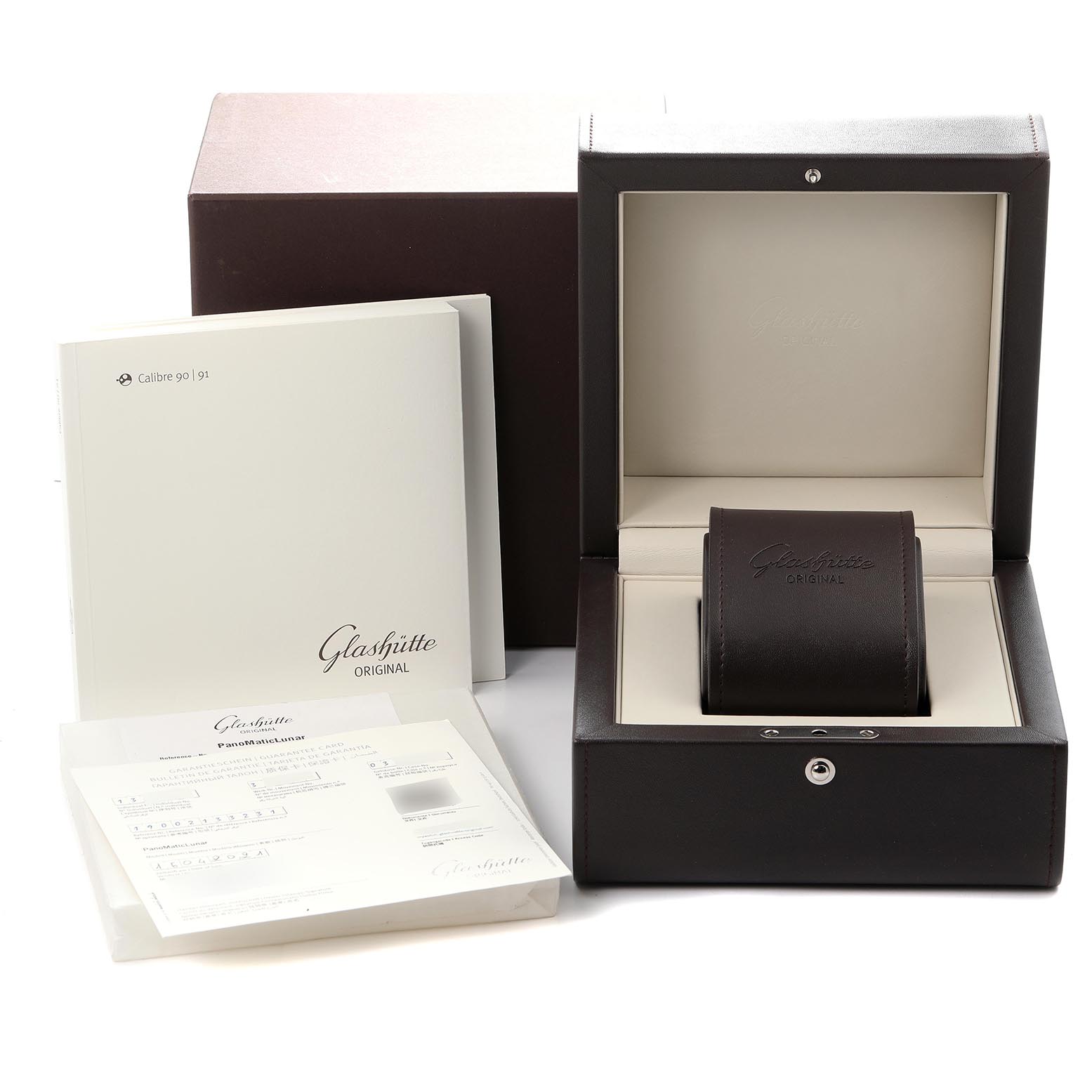 The image shows the packaging and documentation for a Glashütte Pano watch, including the box, pillow, and manuals.