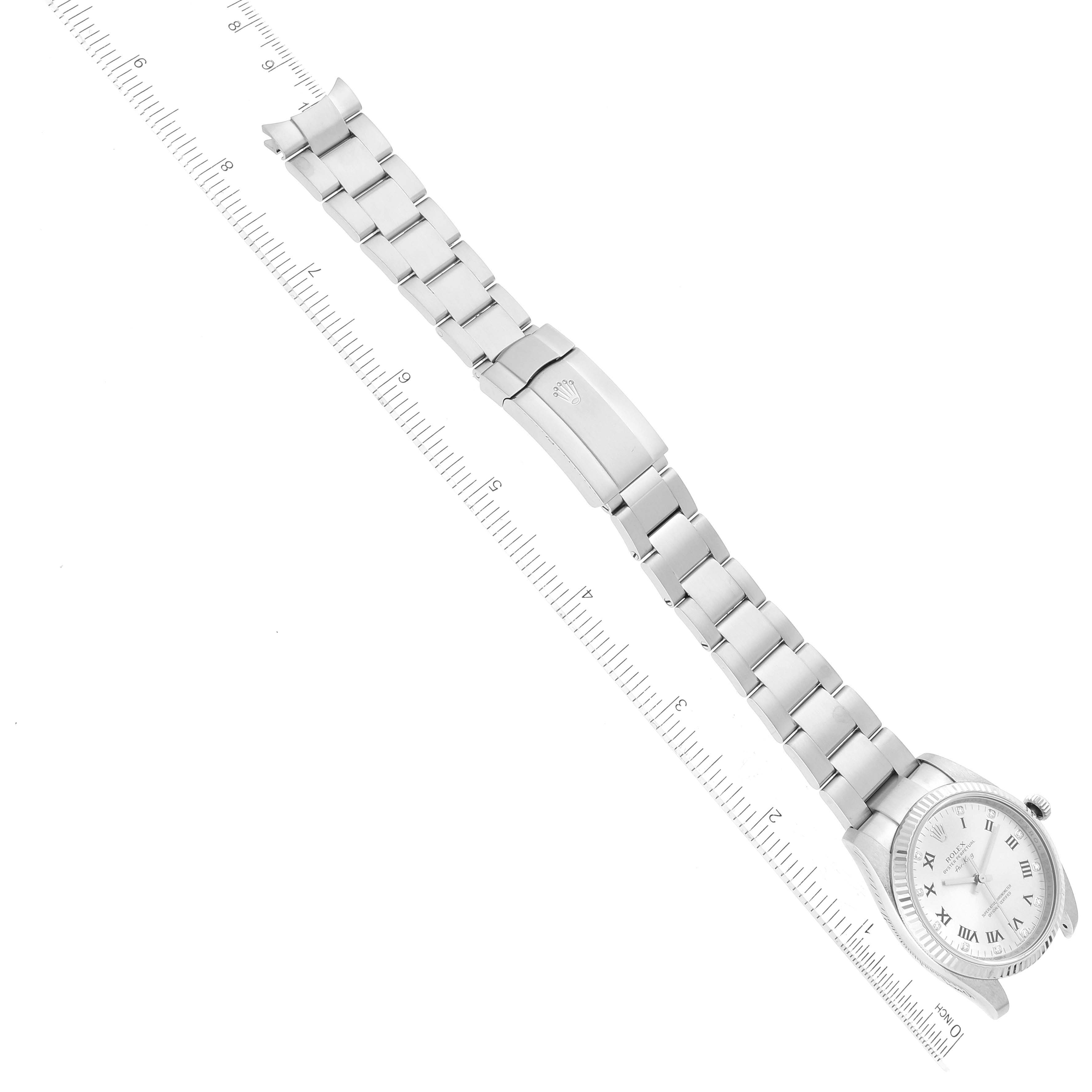 The Rolex Air-King 114234 Men's Stainless Steel Silver Dial 114234 Men's Stainless Steel Silver Dial watch is shown fully extended with its bracelet and clasp visible, placed beside a ruler for scale.