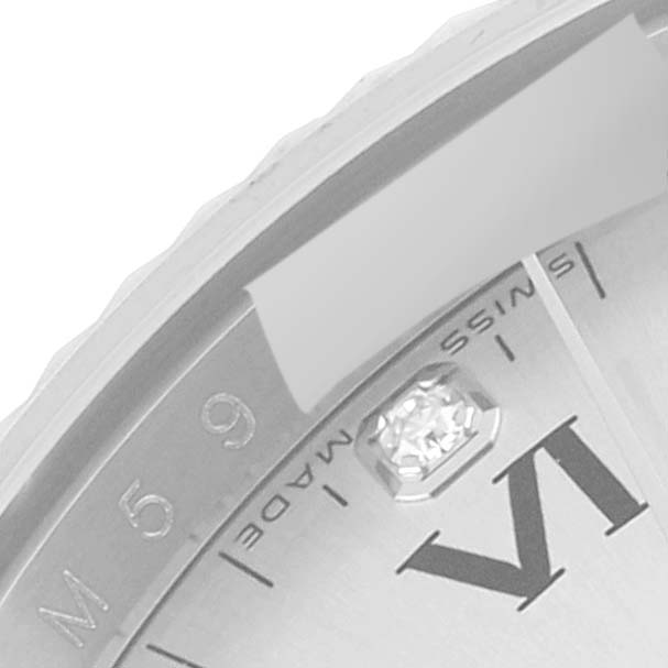 This image shows a close-up angle of the Rolex Air-King 114234 Men's Stainless Steel Silver Dial 114234 Men's Stainless Steel Silver Dial's bezel and part of its dial, featuring the Roman numeral VI and a diamond marker.