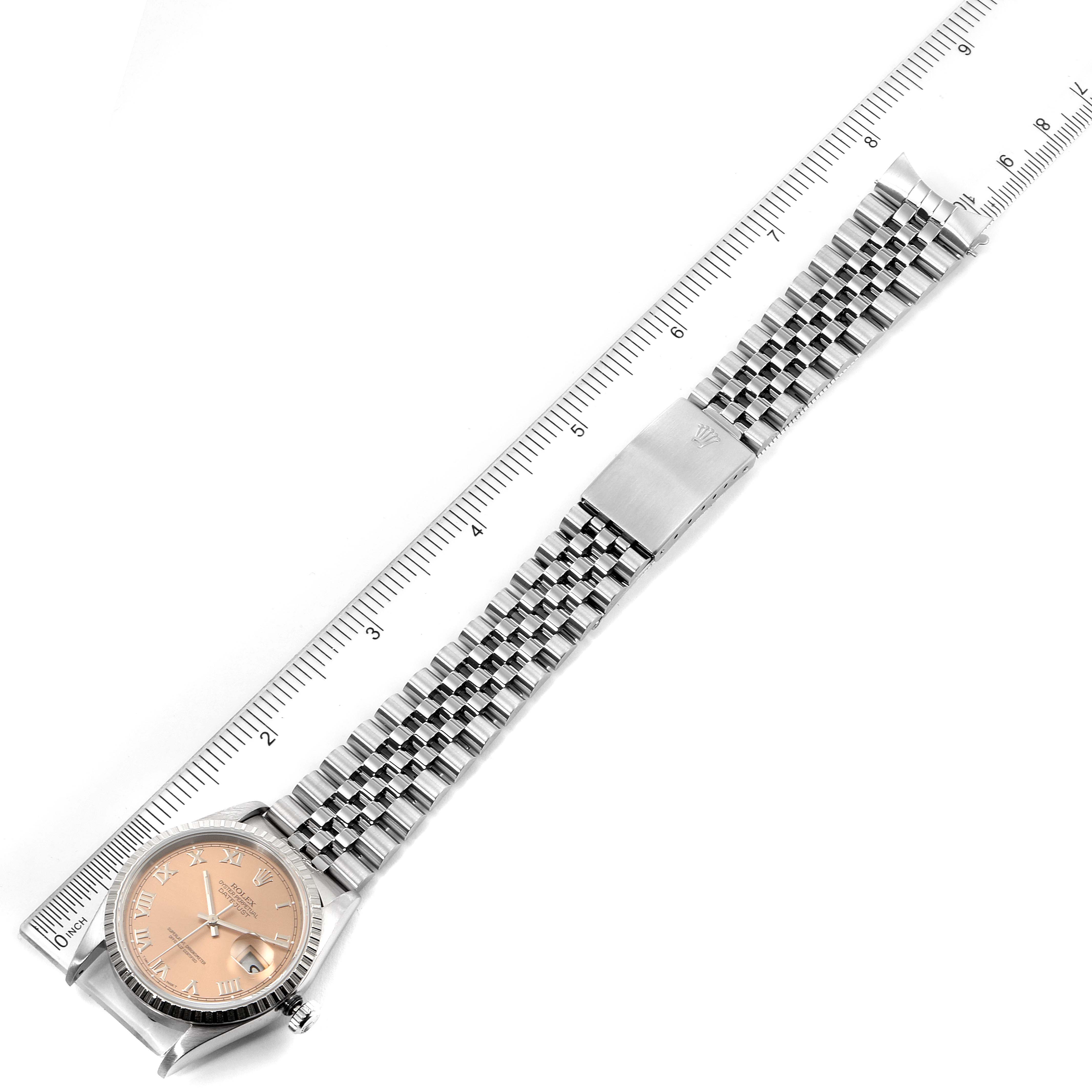 The image shows a Rolex Datejust 16220 Men's Stainless Steel Pink Dial 16220 Men's Stainless Steel Pink Dial watch with a pink dial, bracelet, and clasp, laid flat alongside a ruler.