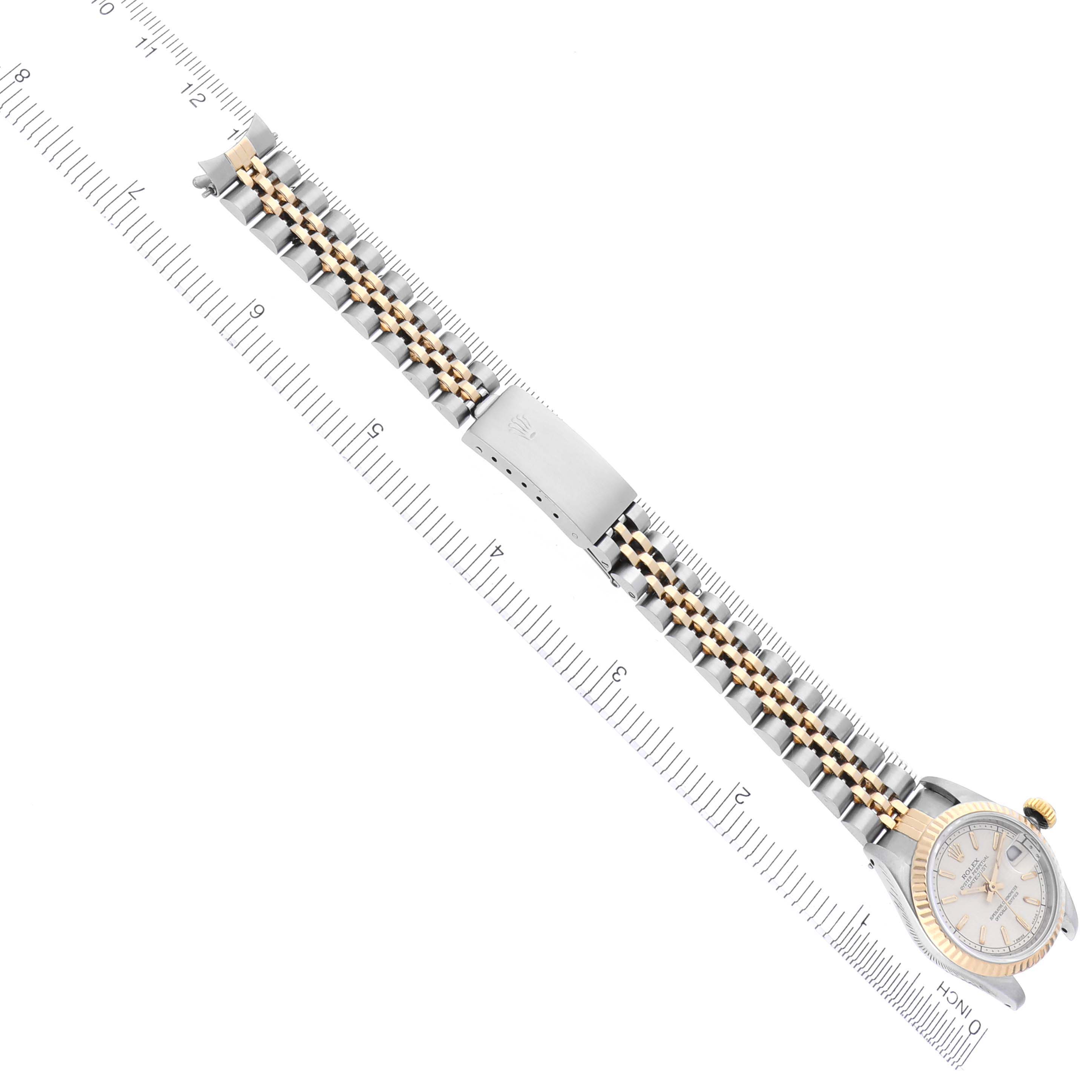 The Rolex Datejust 69173 Women's Steel and Gold (two tone) Beige Dial 69173 Women's Steel and Gold (two tone) Beige Dial watch is shown from a top-down angle, displaying the face, bezel, and bracelet fully extended alongside a ruler.