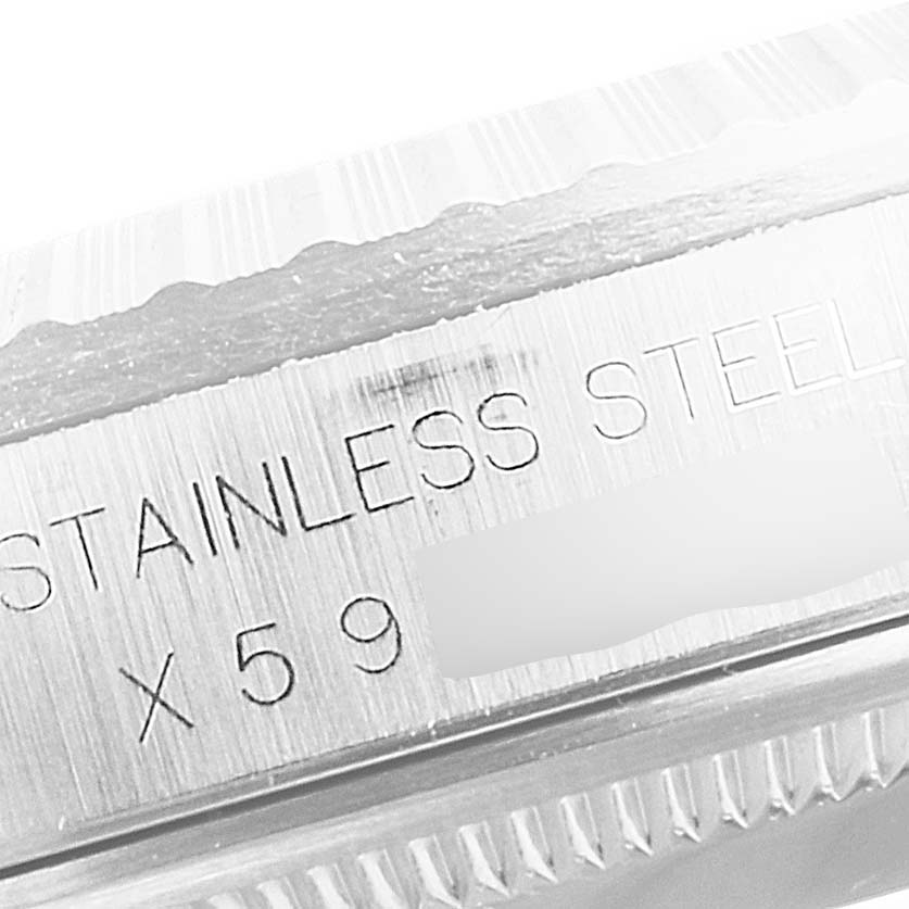 Close-up view of the side of a Rolex Datejust 16220 Men's Stainless Steel Silver Dial 16220 Men's Stainless Steel Silver Dial watch case, showing "STAINLESS STEEL" engraving and part of a serial number.