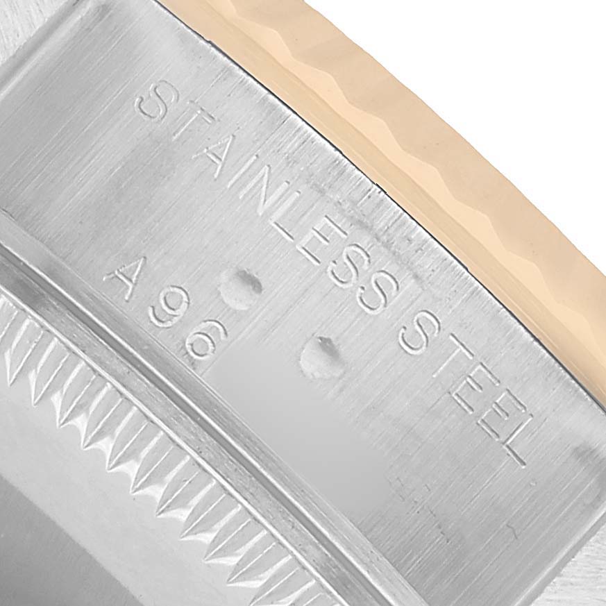 The image shows a close-up of the stainless steel side of a Rolex Datejust 79173 Women's Stainless Steel White Dial watch case, featuring the bezel and engraved text.