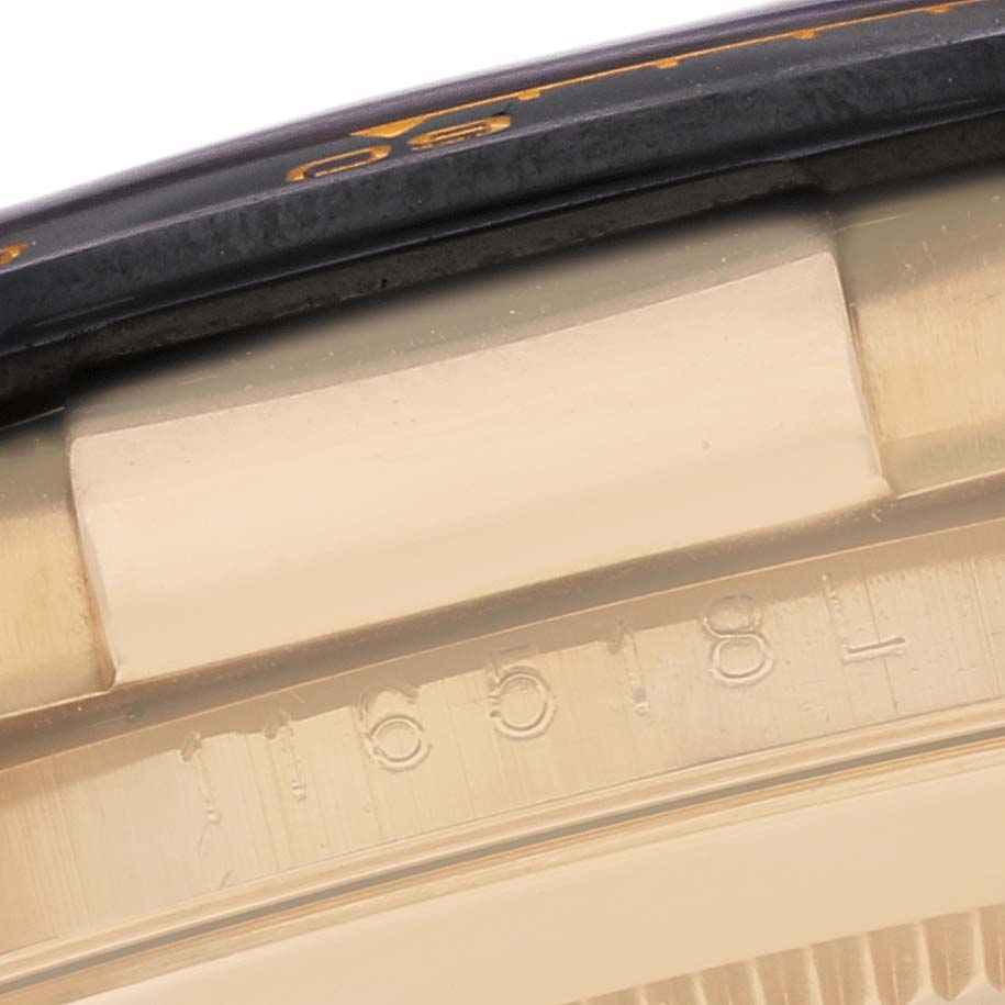 This close-up image of the Rolex Daytona 116518LN Men's Yellow Gold Champagne Dial 116518LN Men's Yellow Gold Champagne Dial shows part of the bezel, serial number, and case side.