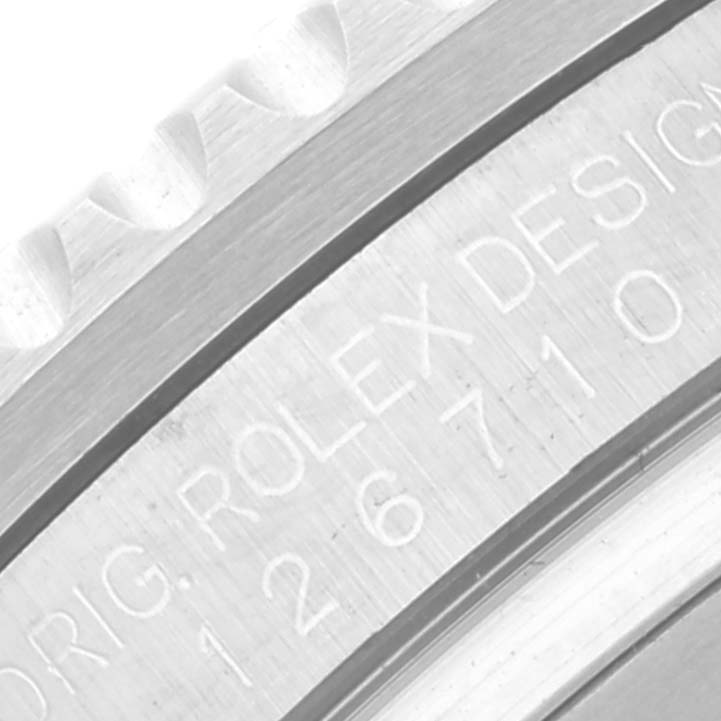 The image shows an angled close-up of the bezel and engraved text on the case of a Rolex GMT-Master 126710BLNR Men
s Stainless Steel Black Dial 126710BLNR Men
s Stainless Steel Black Dial watch.