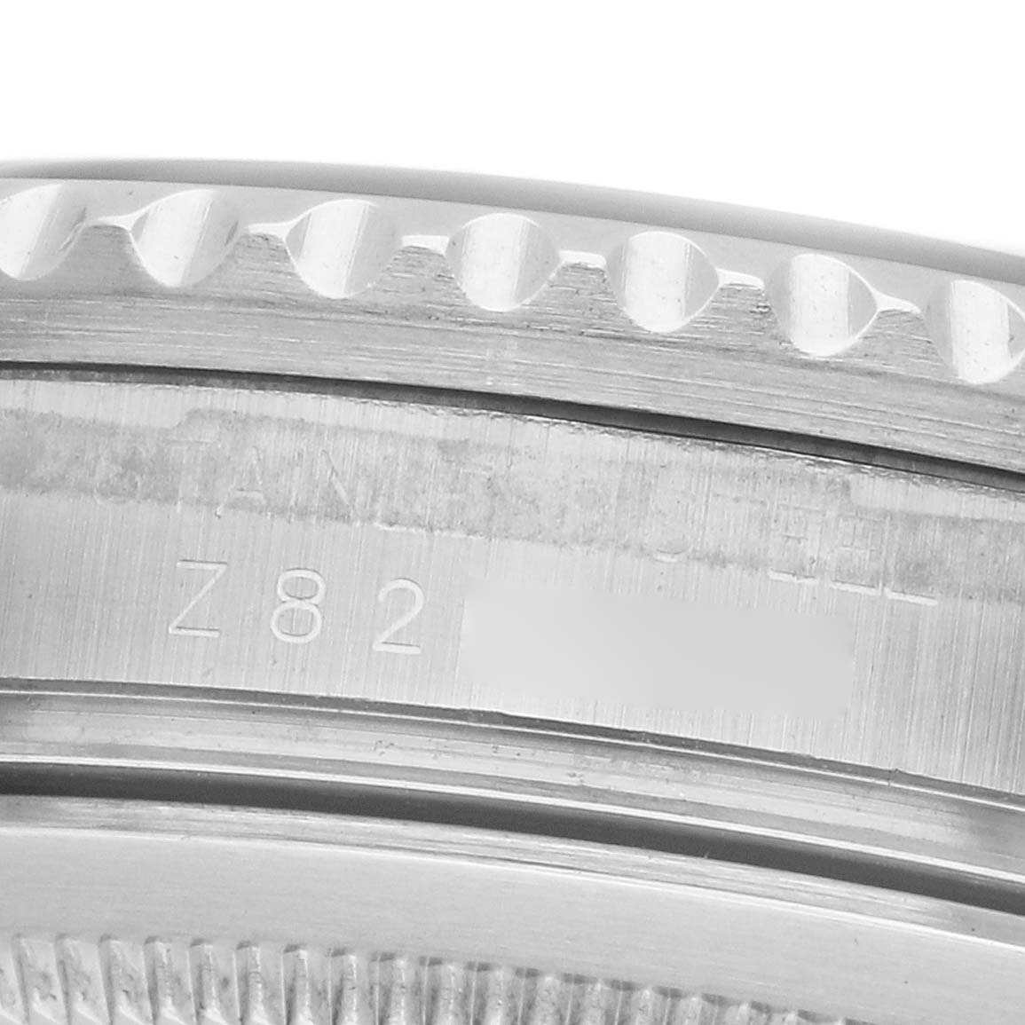 The image shows a close-up of the side view of a Rolex GMT-Master 16710 Men's Stainless Steel Black Dial watch bezel with engraved details.