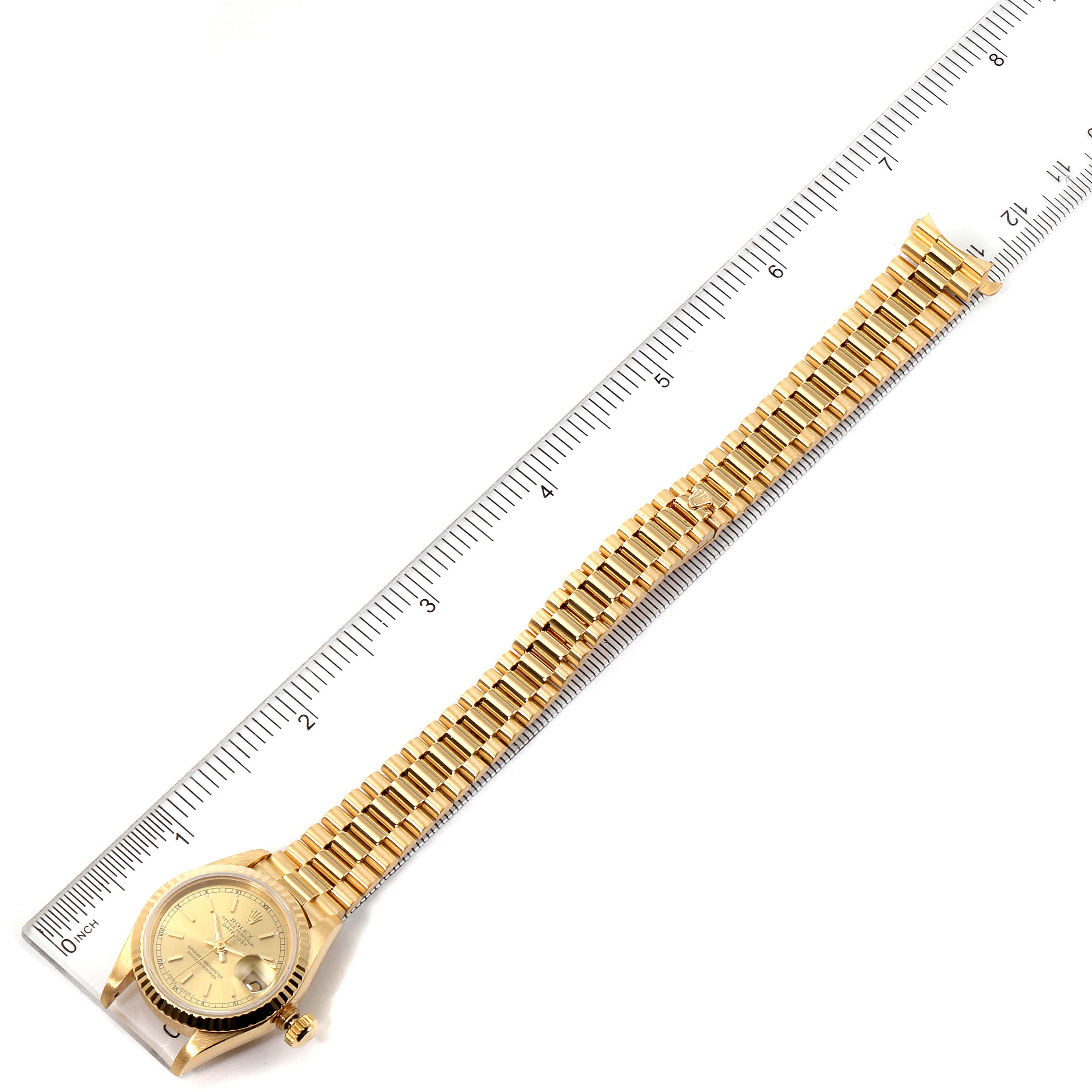 The Rolex President 69178 Women's Yellow Gold Champagne Dial 69178 Women's Yellow Gold Champagne Dial model watch is shown fully extended with a ruler for scale, displaying the face, crown, and the entire bracelet.