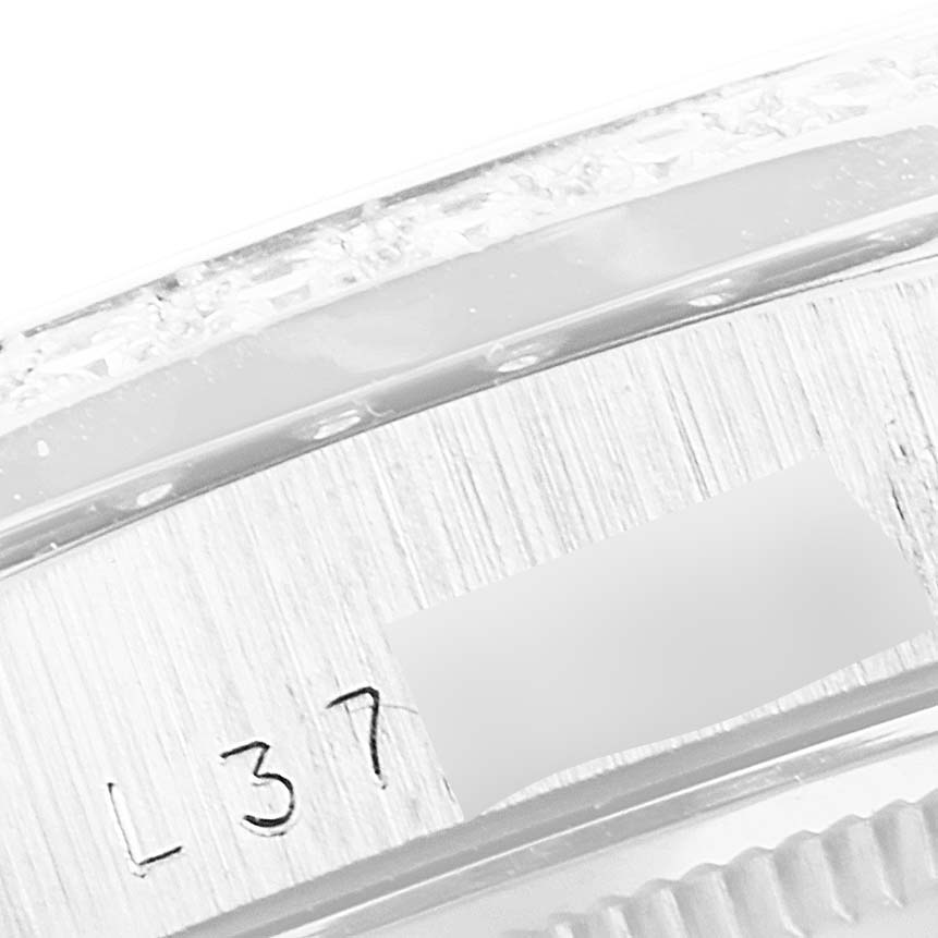 The image shows a close-up of the engraved serial number on the side of a Rolex President 18349 Men's White Gold Silver Dial 18349 Men's White Gold Silver Dial model watch case.