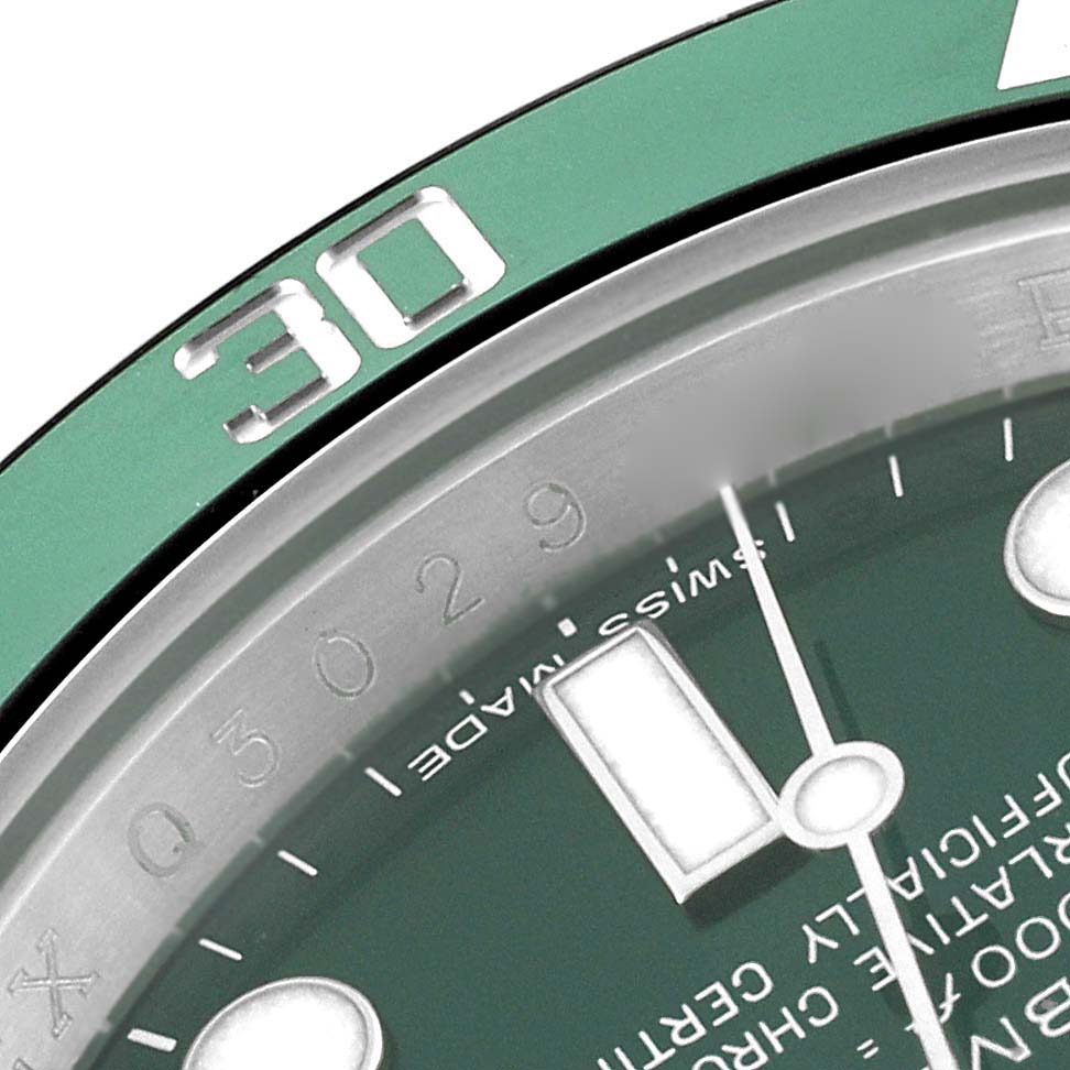 The image shows a close-up of a Rolex Submariner 116610LV Men
s Stainless Steel Green Dial 116610LV Men
s Stainless Steel Green Dial
s green bezel and part of the dial with the hour hand and indices.