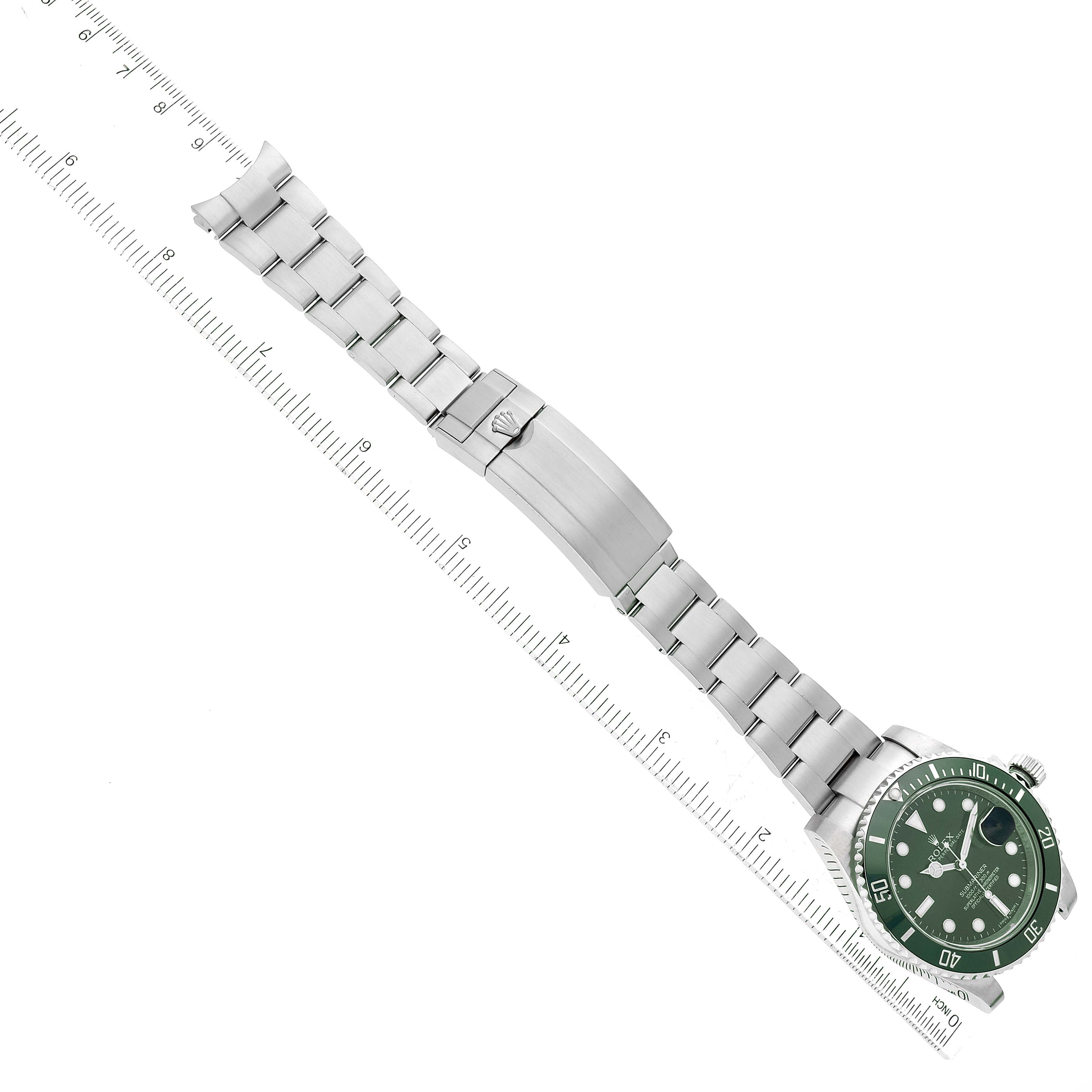 The Rolex Submariner 116610LV Men
s Stainless Steel Green Dial 116610LV Men
s Stainless Steel Green Dial watch is shown laid flat with a ruler alongside it, showcasing the bracelet and dial.