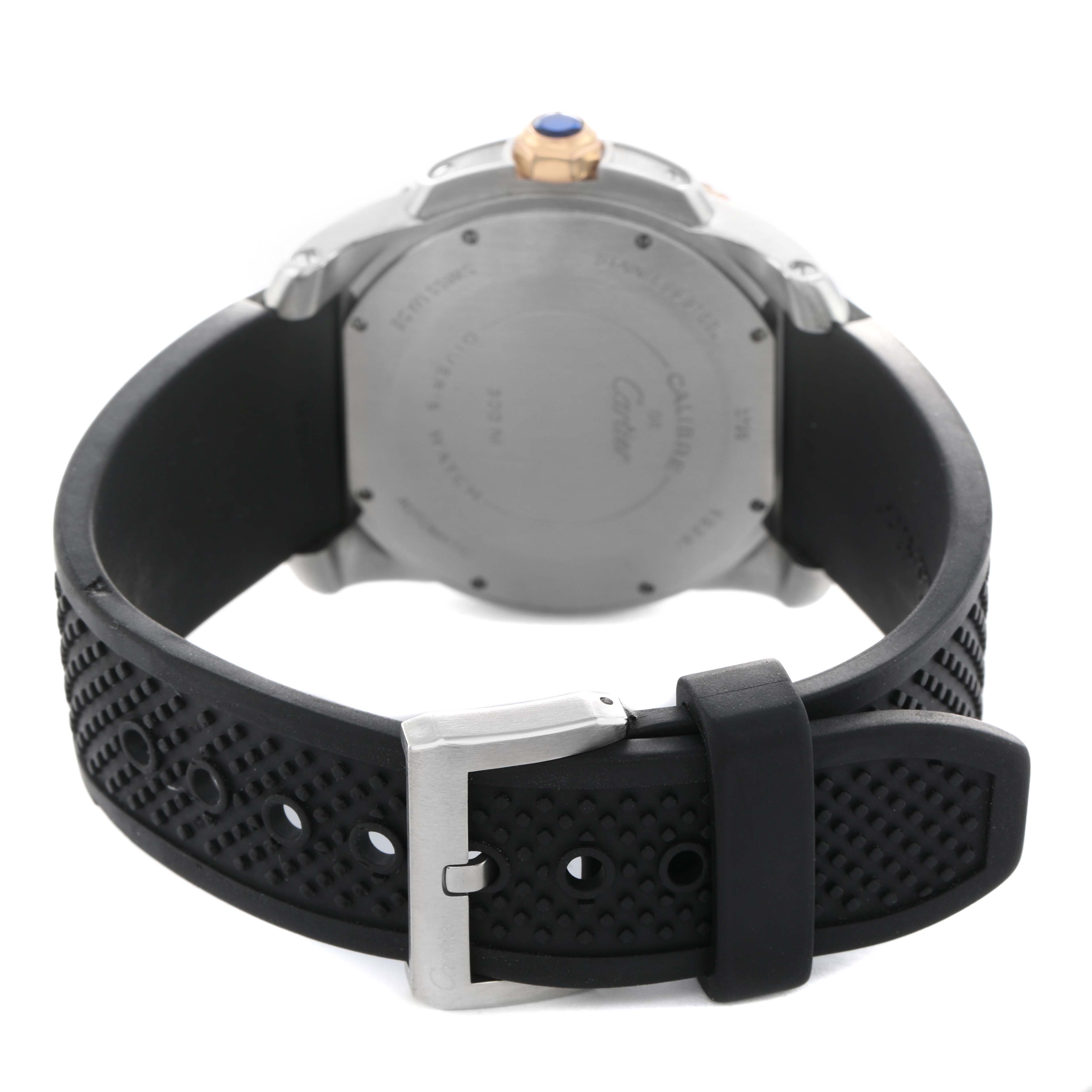 The image shows the back and side of the Calibre de Cartier watch, highlighting the case back, crown, and black textured strap with a buckle.