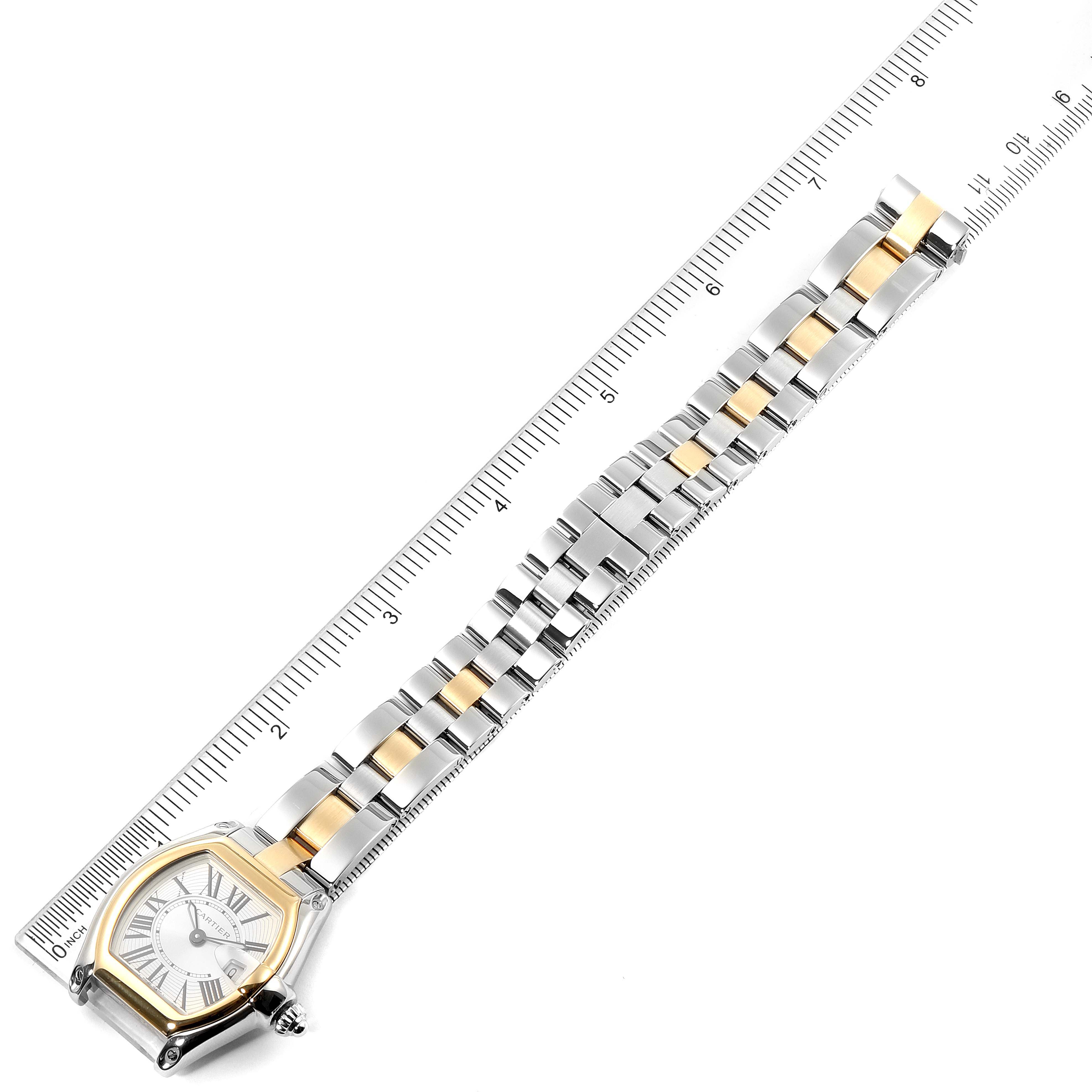 The Cartier Roadster W62026Y4 Women's Steel and Gold (two tone) Silver Dial W62026Y4 Women's Steel and Gold (two tone) Silver Dial watch is shown from a top-down angle, displaying its face, bezel, and entire bracelet, alongside a ruler for size reference.