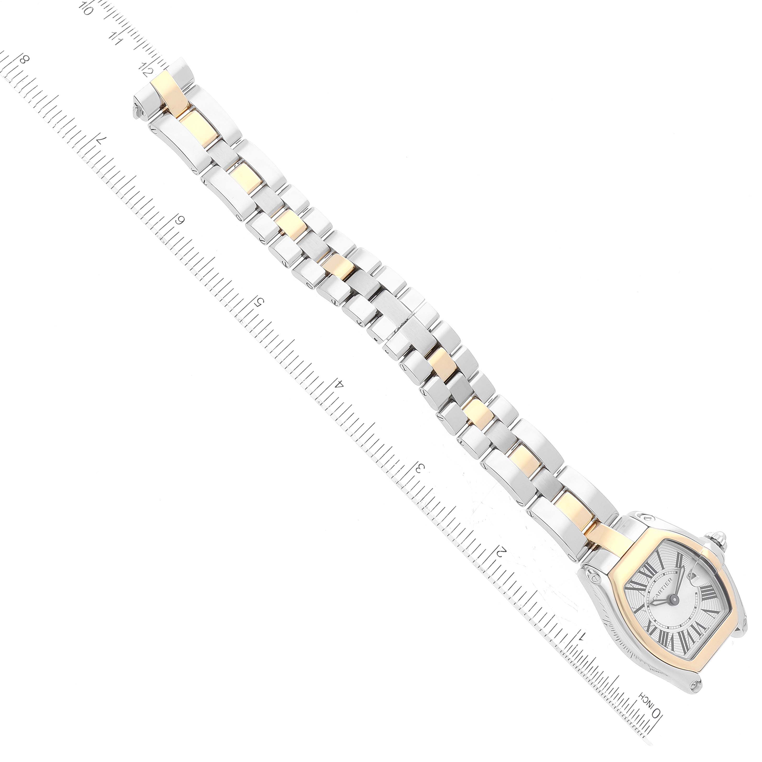 The image shows the Cartier Roadster W62026Y4 Women's Steel and Gold (two tone) Silver Dial W62026Y4 Women's Steel and Gold (two tone) Silver Dial watch laid flat, displaying its face, bracelet, and a ruler for size reference.