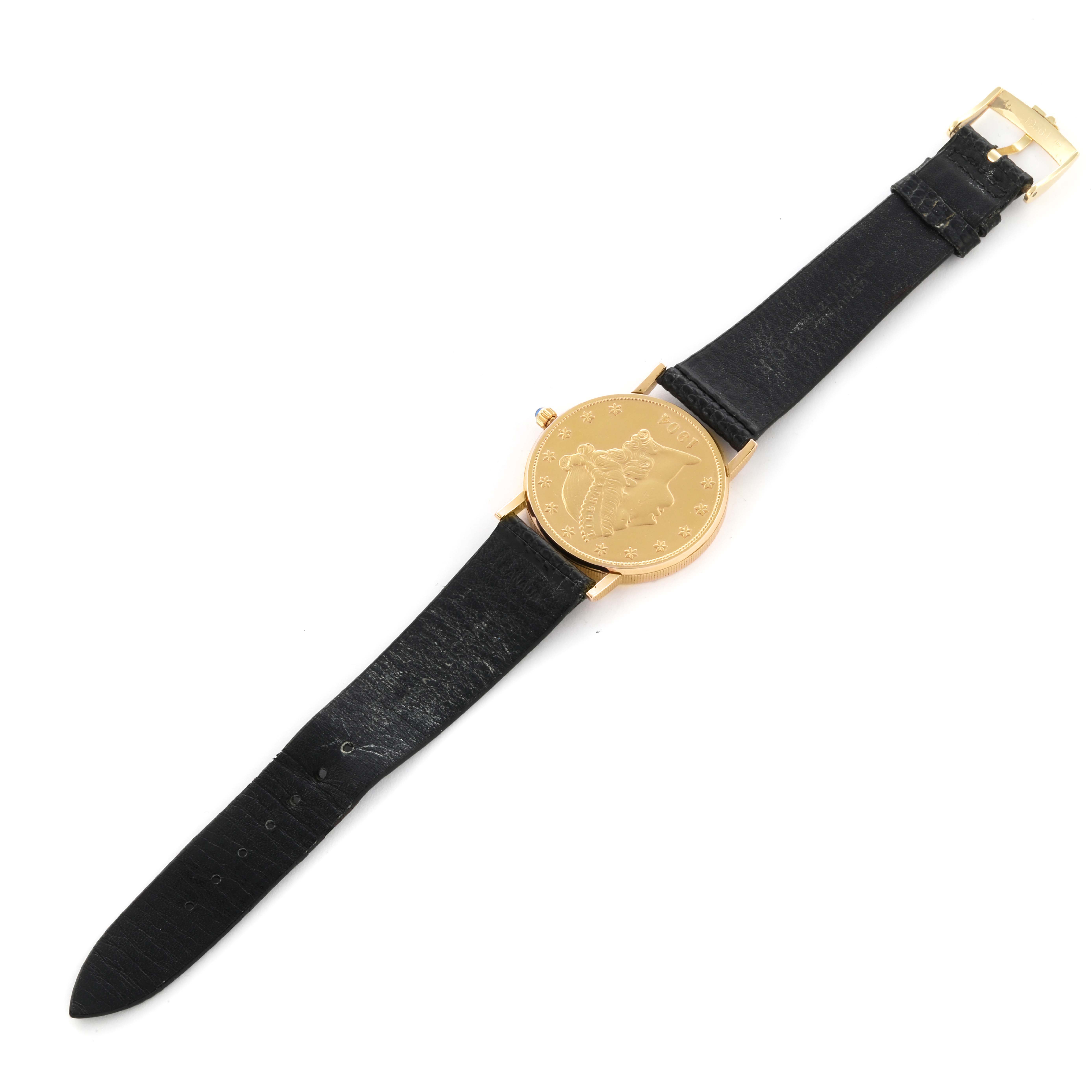 The Corum Coin Watch Men's Yellow Gold Champagne Dial Men's Yellow Gold Champagne Dial is shown from a top-down angle, highlighting its gold case and black leather strap.