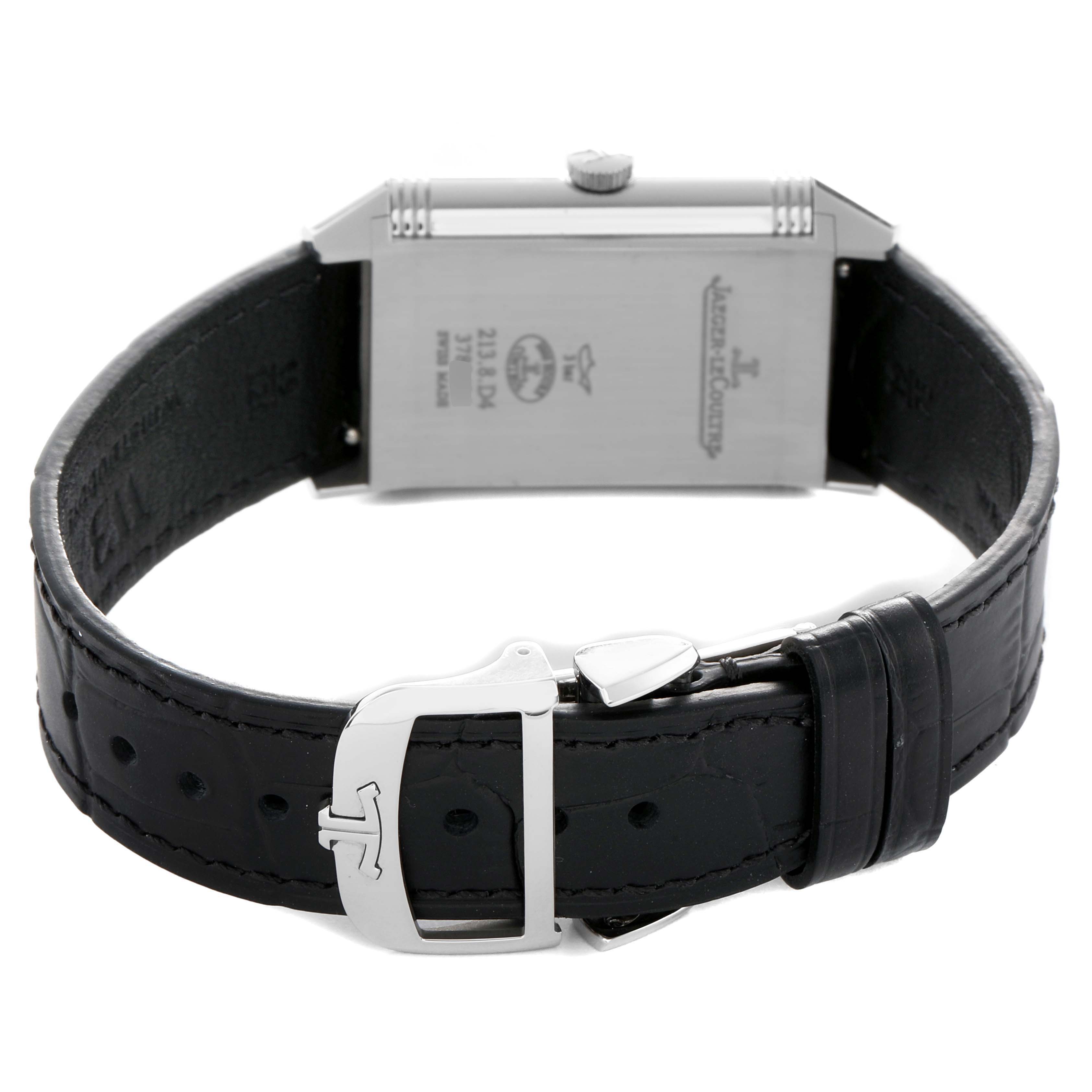 The Jaeger-LeCoultre Reverso watch is shown from the back, highlighting the case, leather strap, and buckle.
