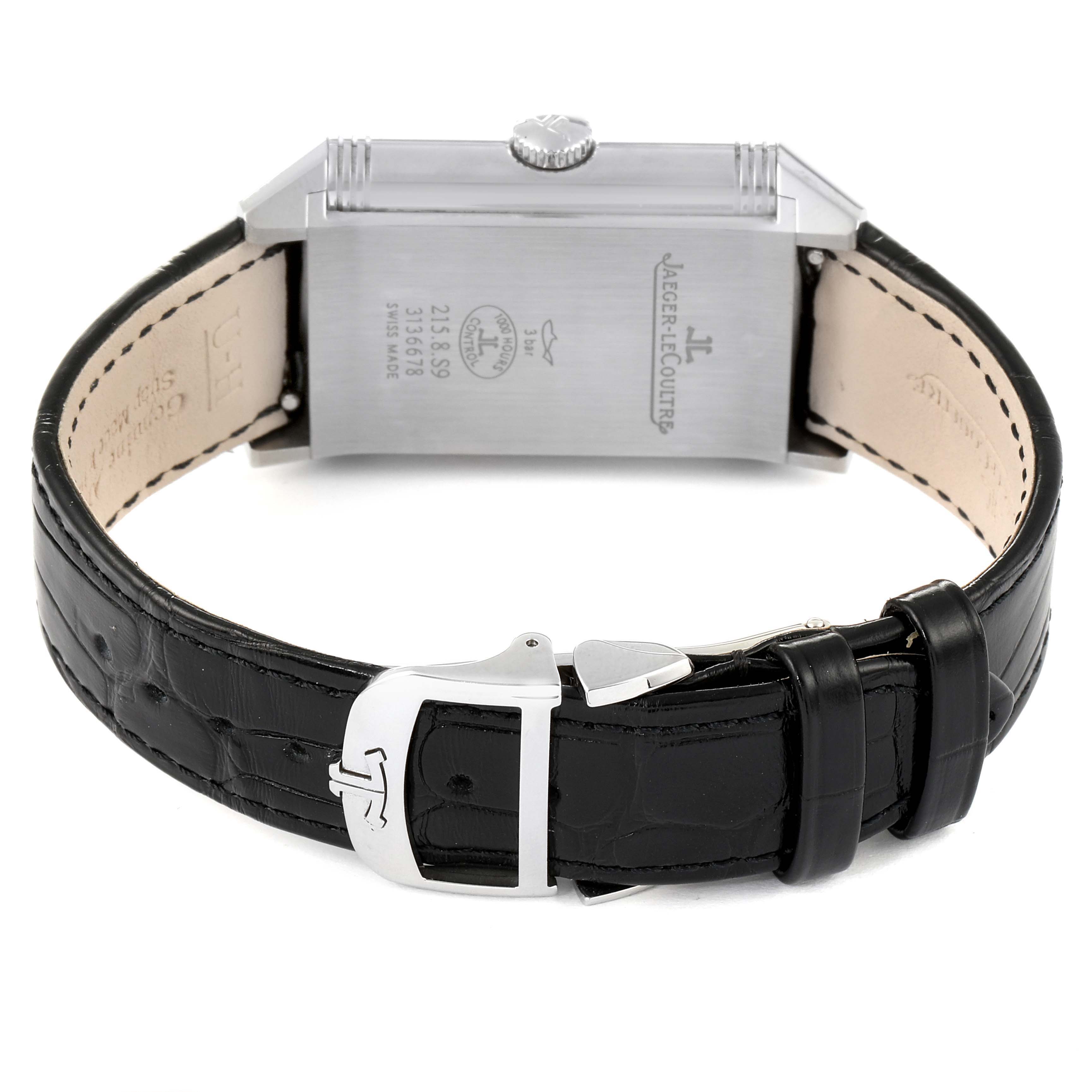 The image shows the back side and strap of a Jaeger-LeCoultre Reverso watch, highlighting the engraved case back and leather strap with a clasp.