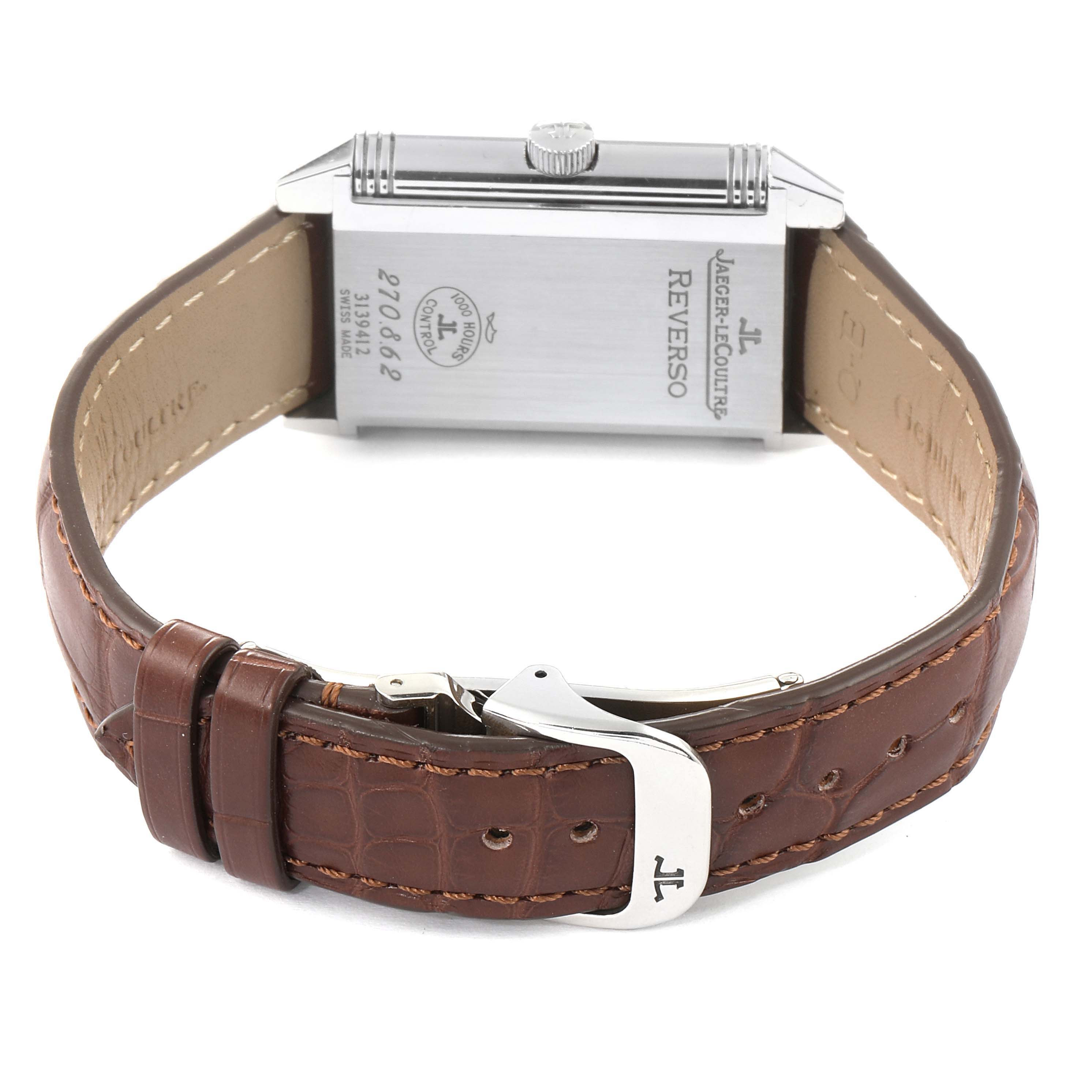 The image shows the back of a Jaeger-LeCoultre Reverso watch, highlighting its brown leather strap and metal clasp.