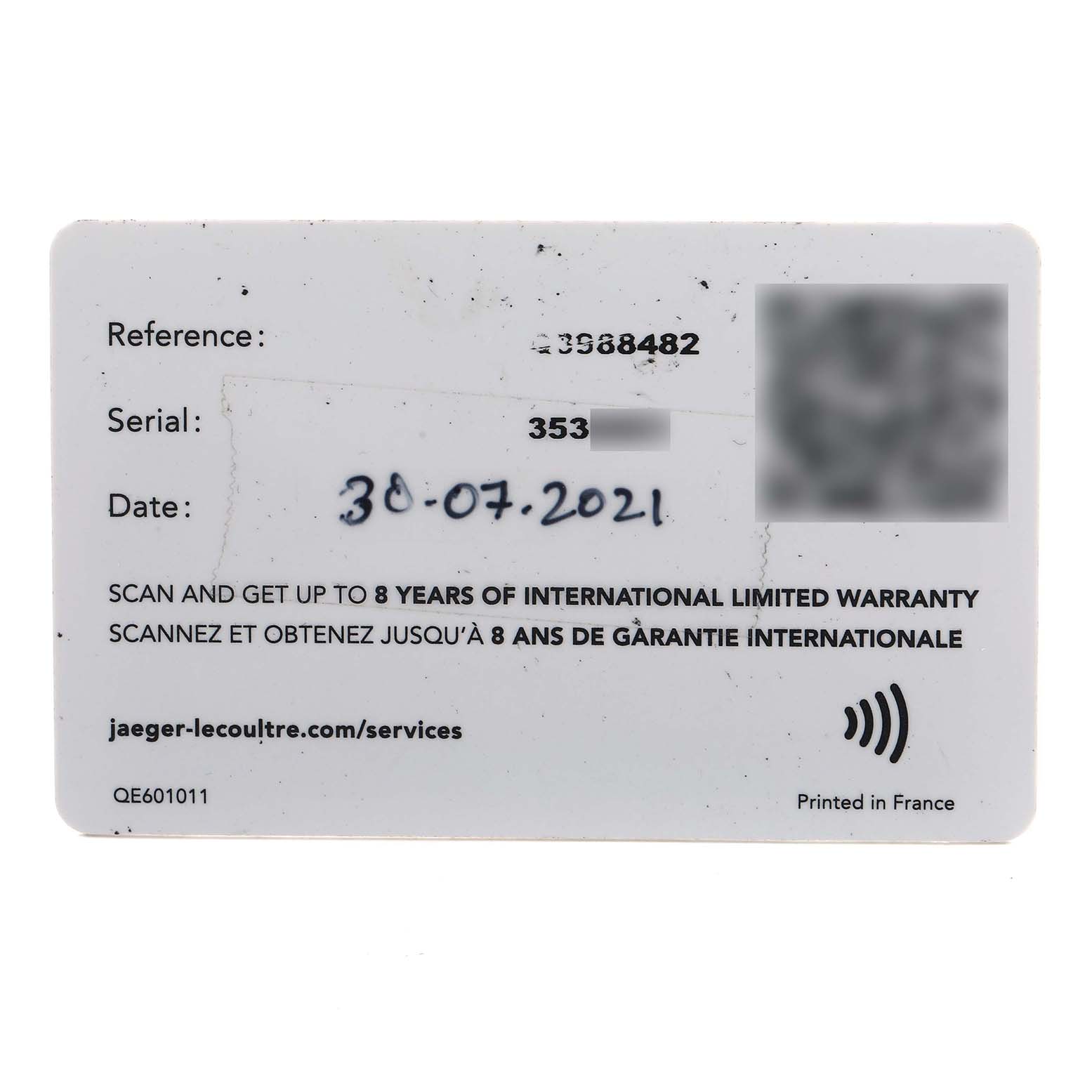 The image shows a Jaeger LeCoultre Reverso Q3988482/215.8.D4 Men's Stainless Steel Blue Dial warranty card from a top-down angle, displaying reference, serial, and date information.