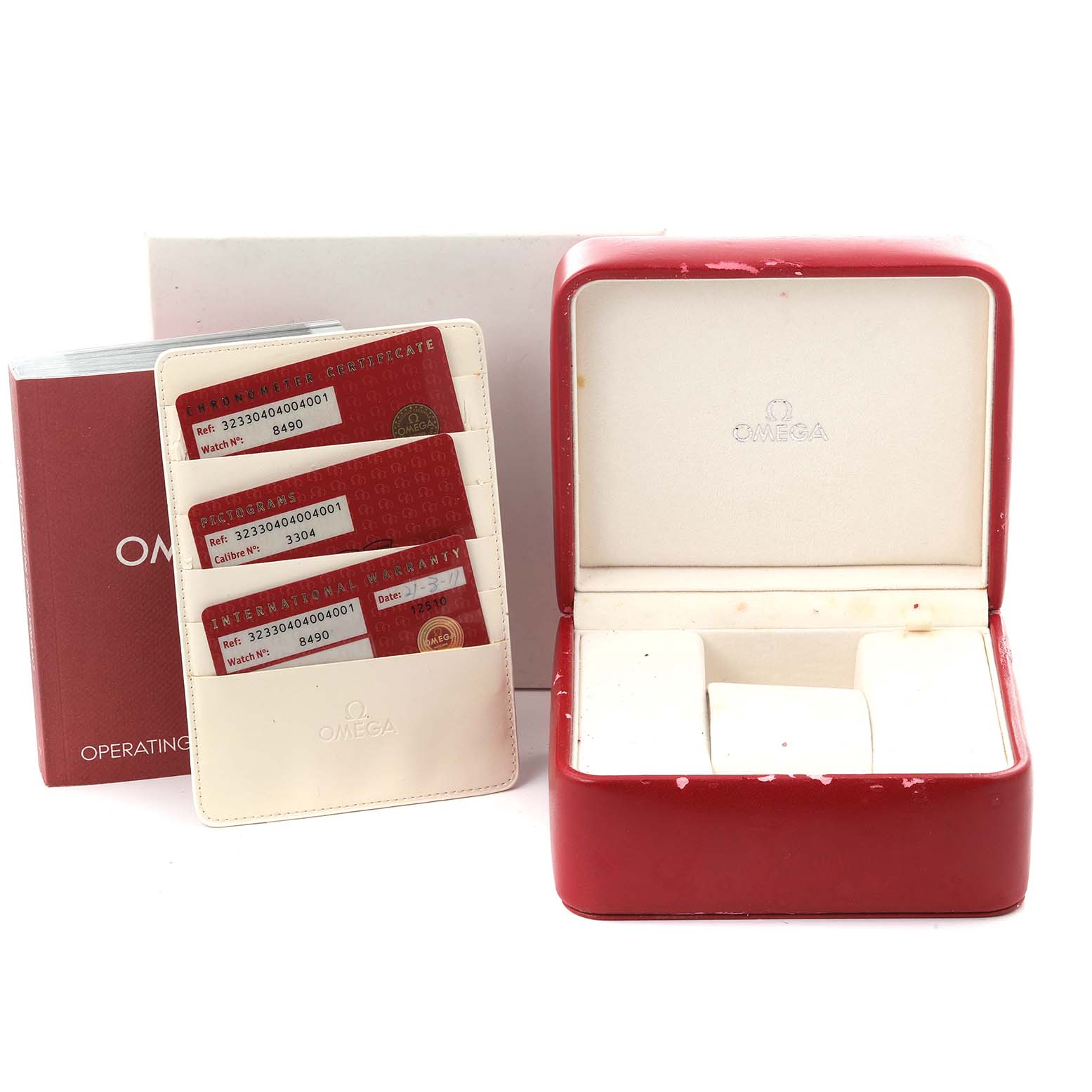 The image shows an Omega Speedmaster 323.30.40.40.04.001 Men
s Stainless Steel Silver Dial 323.30.40.40.04.001 Men
s Stainless Steel Silver Dial box, operating manual, cardholder, and warranty cards from a front angle.