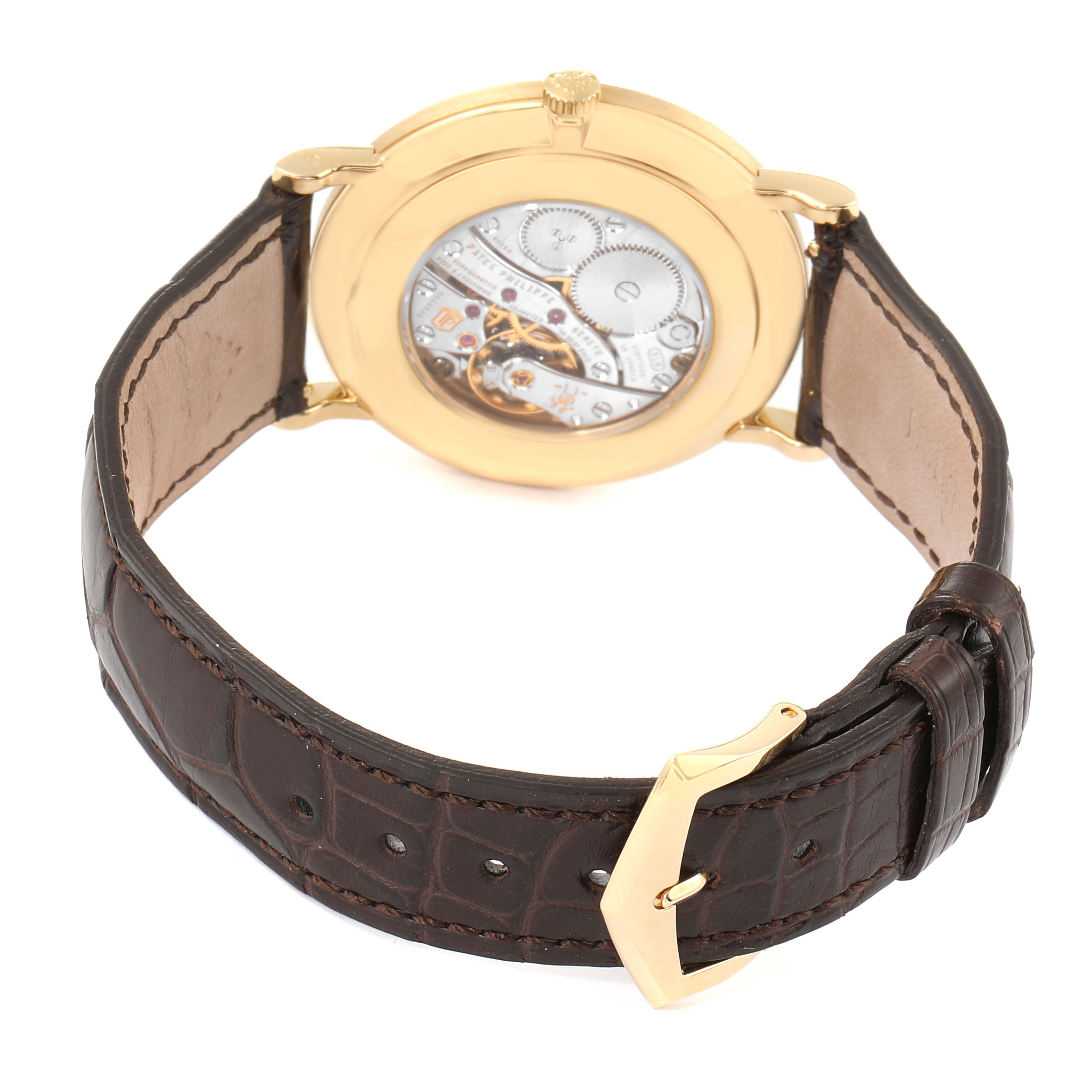 This image of the Patek Philippe Calatrava 5119J Men's Yellow Gold White Dial 5119J Men's Yellow Gold White Dial watch shows the back, revealing the mechanical movement and brown leather strap with gold buckle.