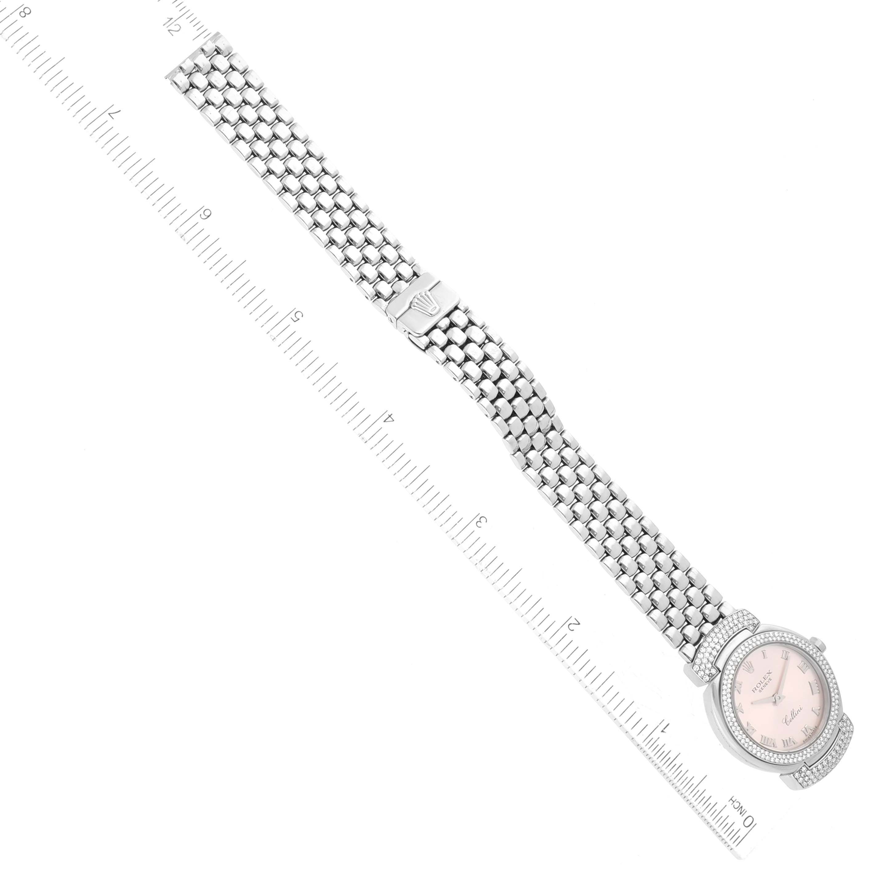 The image shows a Rolex Cellini 6673 Women
s White Gold Pink Dial 6673 Women
s White Gold Pink Dial watch with a metallic mesh band and a ruler for size reference, viewed from the top.