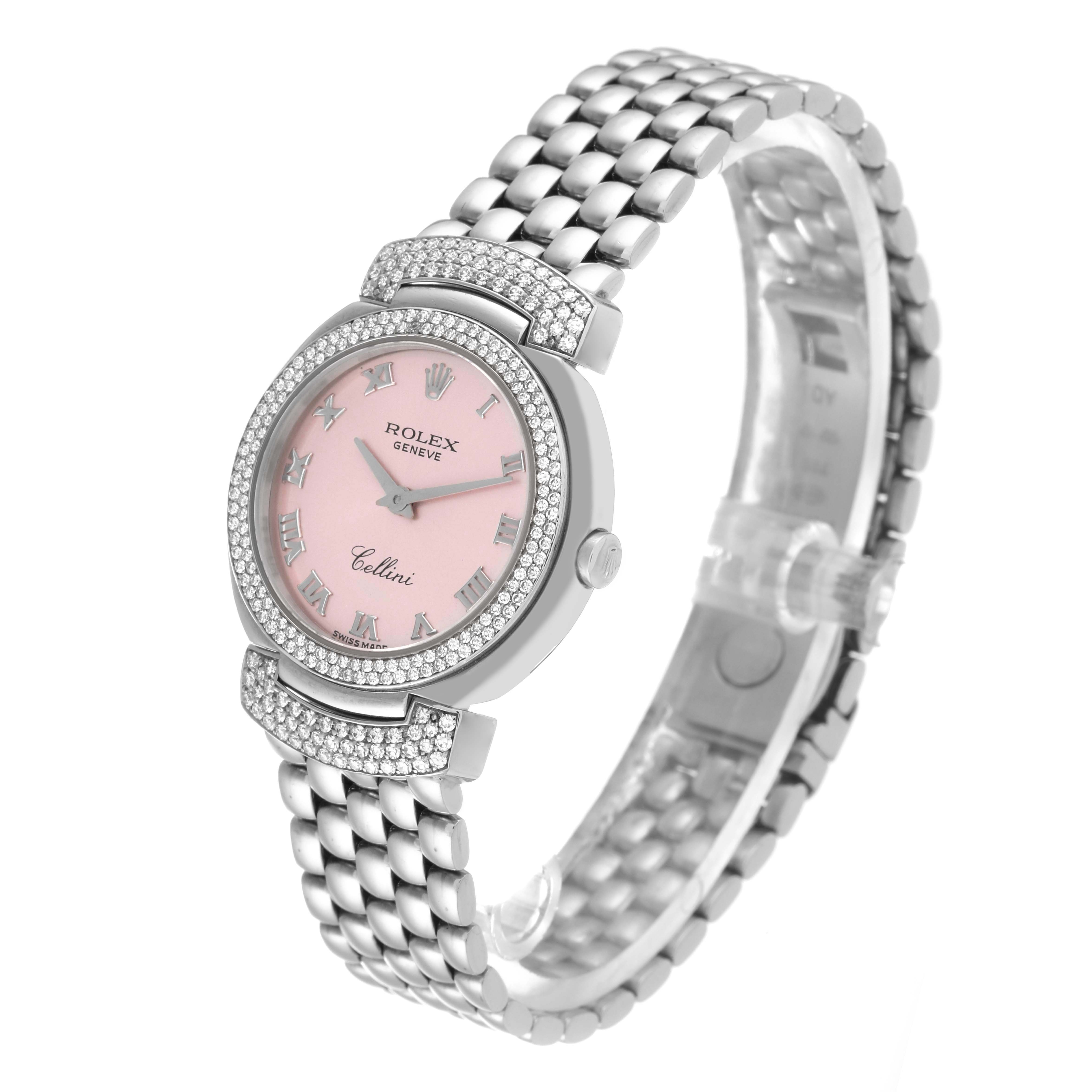 The Rolex Cellini 6673 Women
s White Gold Pink Dial 6673 Women
s White Gold Pink Dial watch is shown from an angled view, displaying its pink dial, diamond-studded bezel, and metal bracelet.