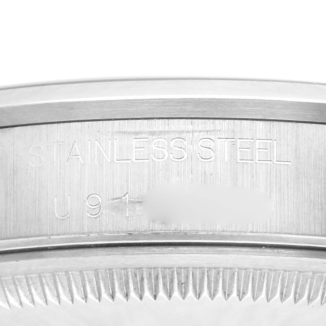 The image shows a close-up of a Rolex Date 15200 Men's Stainless Steel Blue Dial 15200 Men's Stainless Steel Blue Dial model's stainless steel case back with engraved serial numbers.