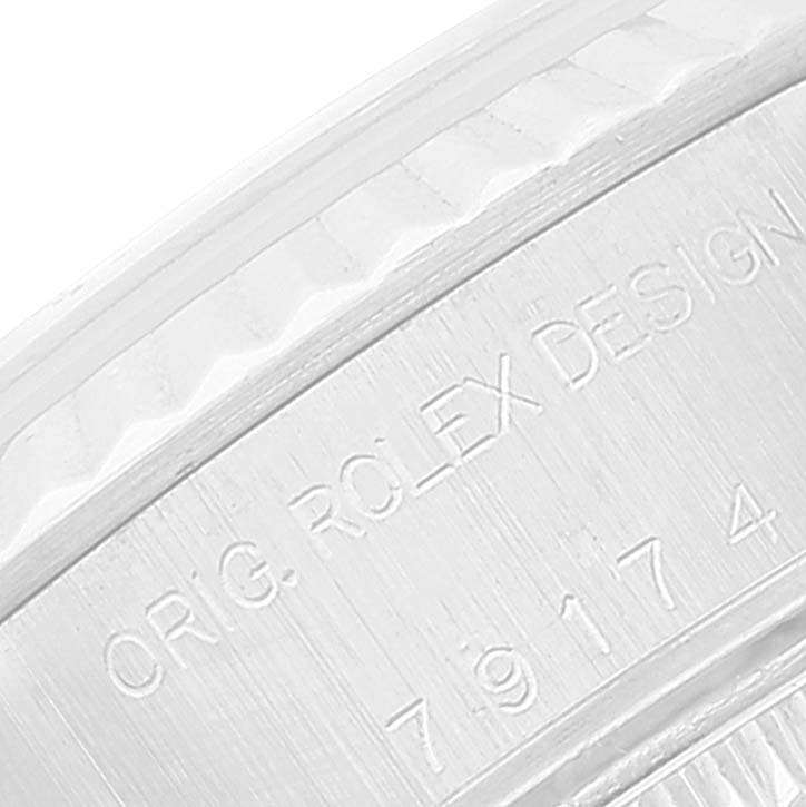 This is a close-up view of the Rolex Datejust 79174 Women's Stainless Steel Silver Dial 79174 Women's Stainless Steel Silver Dial watch showing the engraved text and part of the fluted bezel.