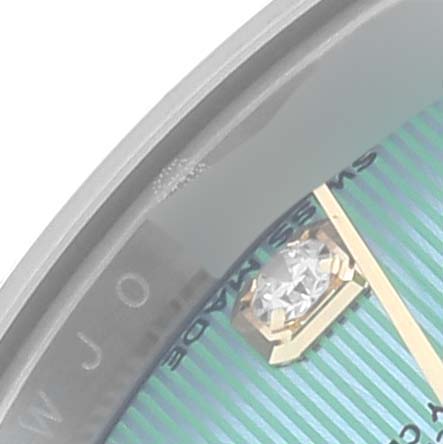 The image shows a close-up of the Rolex Mid-Size watch face, featuring the edge, a diamond marker, and partial text.