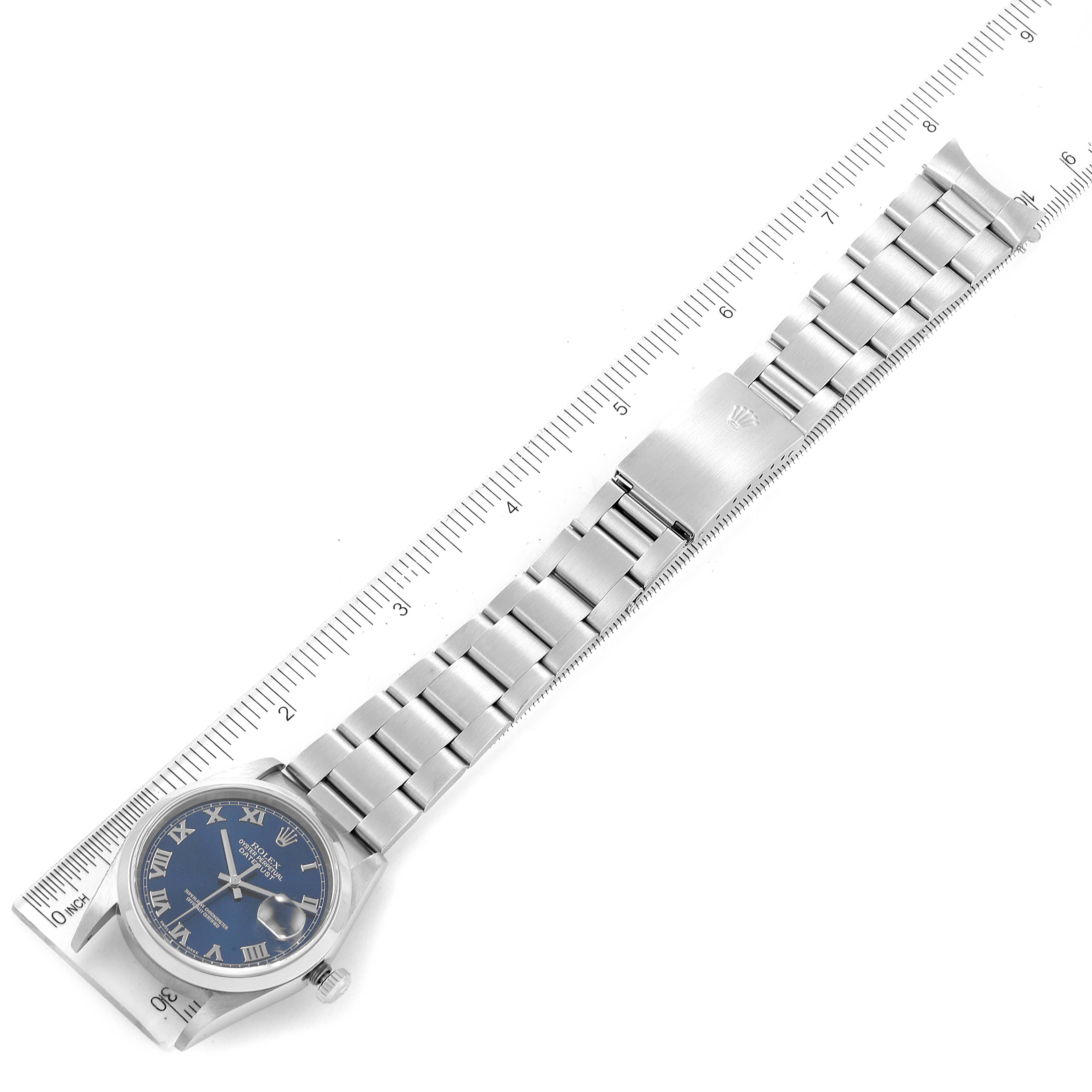 This image shows a top-down view of a Rolex Datejust 16200 Men's Stainless Steel Blue Dial 16200 Men's Stainless Steel Blue Dial watch with a blue dial and a stainless steel bracelet placed alongside a ruler.