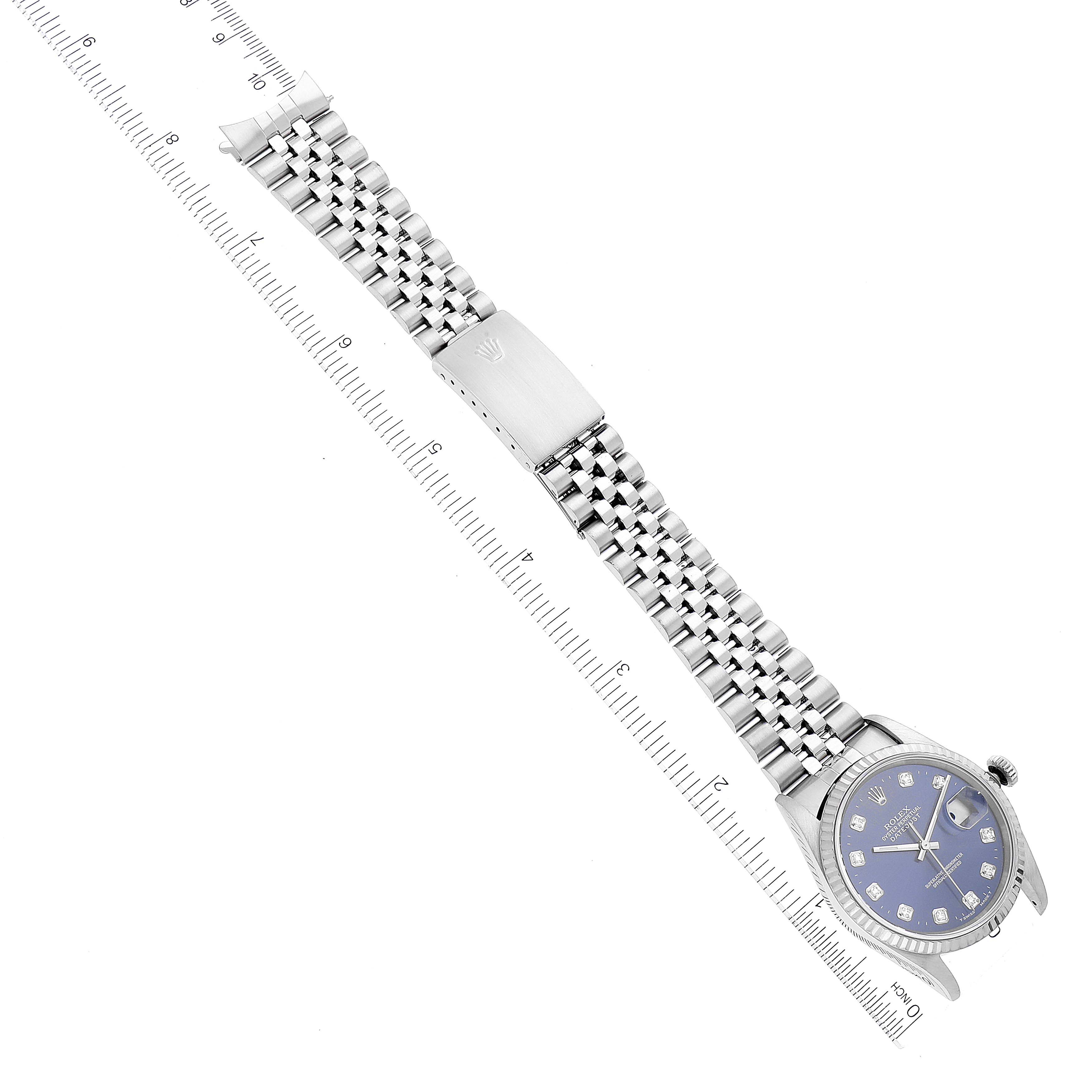 The image shows a Rolex Datejust 16234 Men's Stainless Steel Blue Dial 16234 Men's Stainless Steel Blue Dial watch laid flat with its Jubilee bracelet, including the clasp and dial, with rulers for scale.