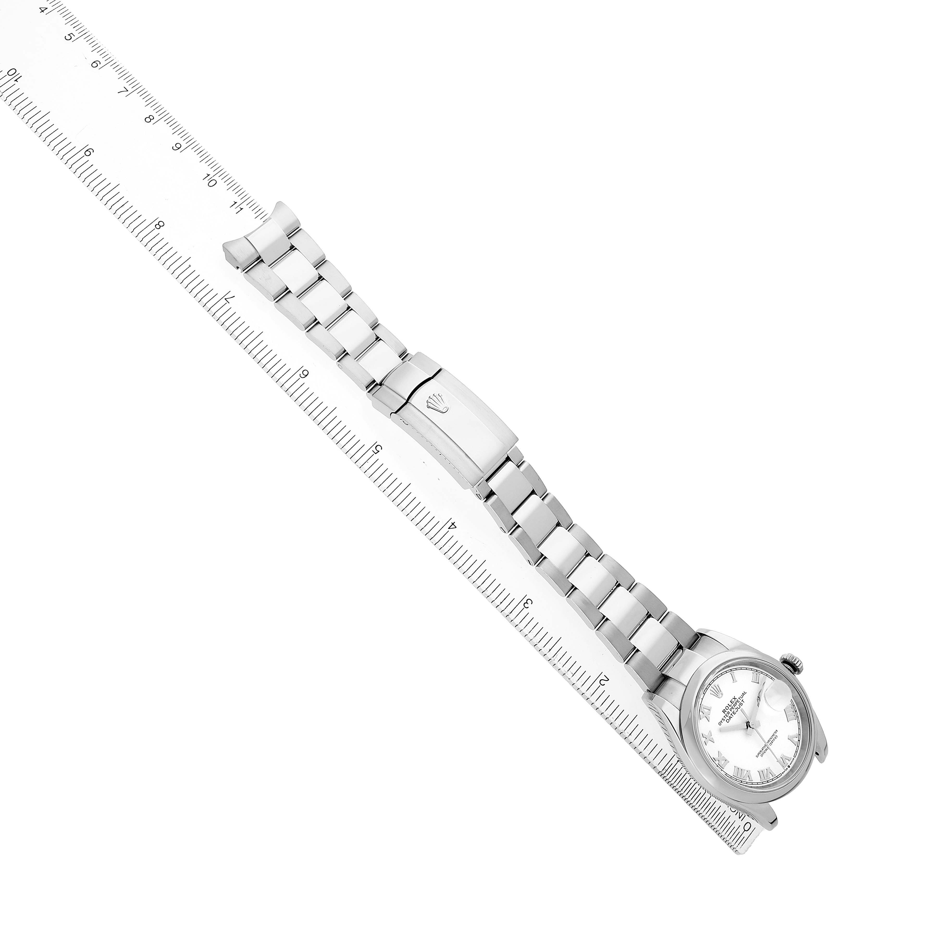 The Rolex Datejust 126200 Men's Stainless Steel White Dial watch is shown from a top angle, featuring the full bracelet, clasp, and face with a ruler alongside for scale.