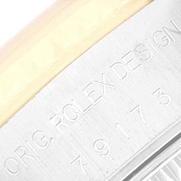 This close-up image of the Rolex Datejust 79173 Women's Steel and Gold (two tone) Champagne Dial 79173 Women's Steel and Gold (two tone) Champagne Dial watch shows part of the bezel and engraved text on the case.