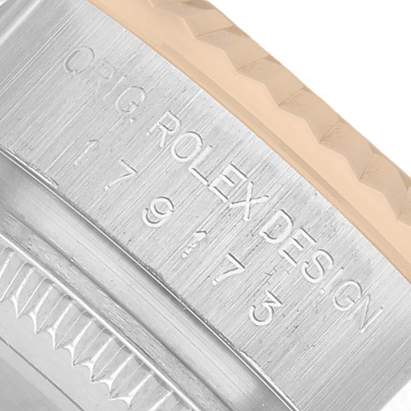 The image shows a close-up of the engraving on the side of a Rolex Datejust 179173 Men's Steel and Gold (two tone) Silver Dial bezel, highlighting the text and fluted edge.