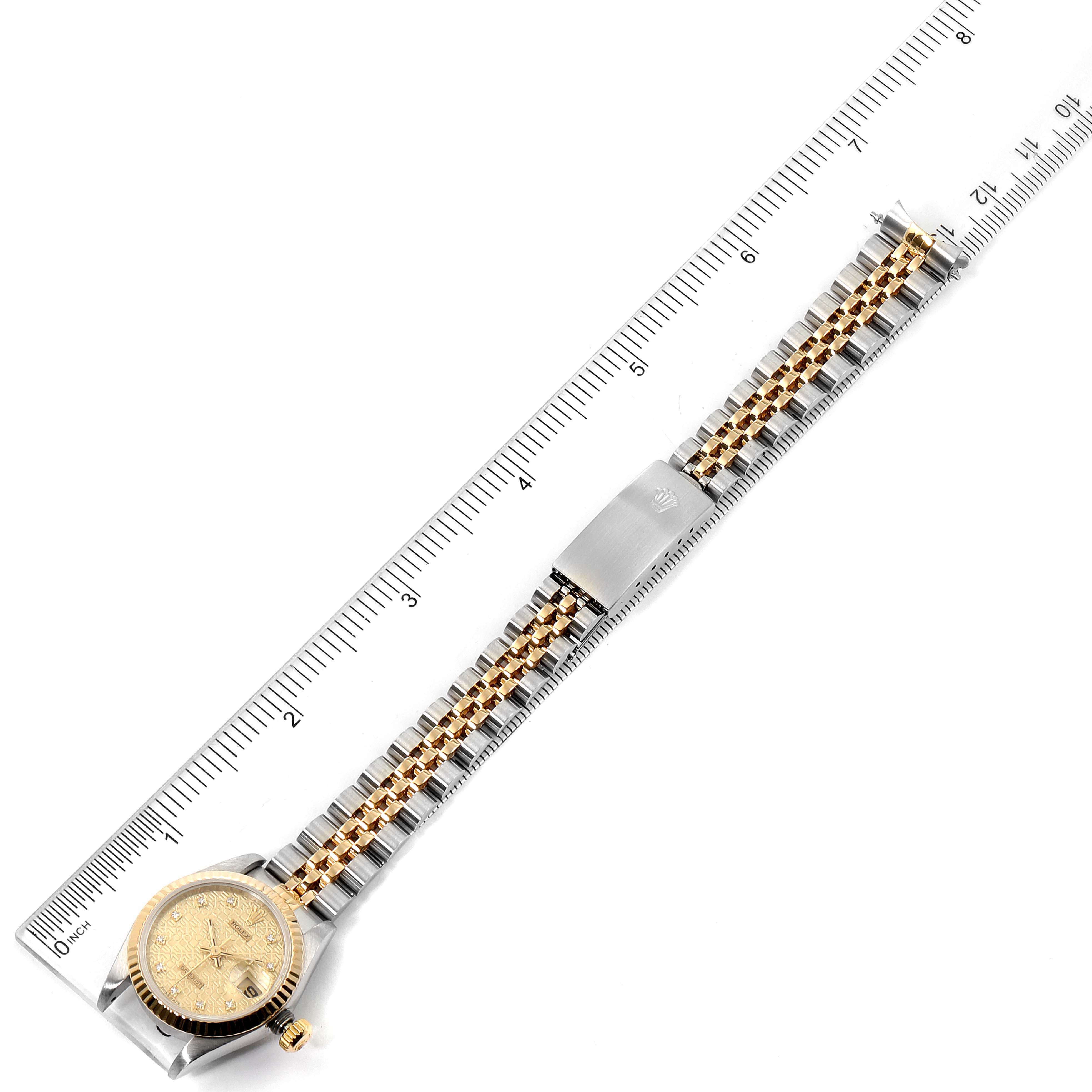 This image shows a full view of the Rolex Datejust 69173 Women's Steel and Gold (two tone) Champagne Dial 69173 Women's Steel and Gold (two tone) Champagne Dial watch laid flat next to a ruler displaying its length.