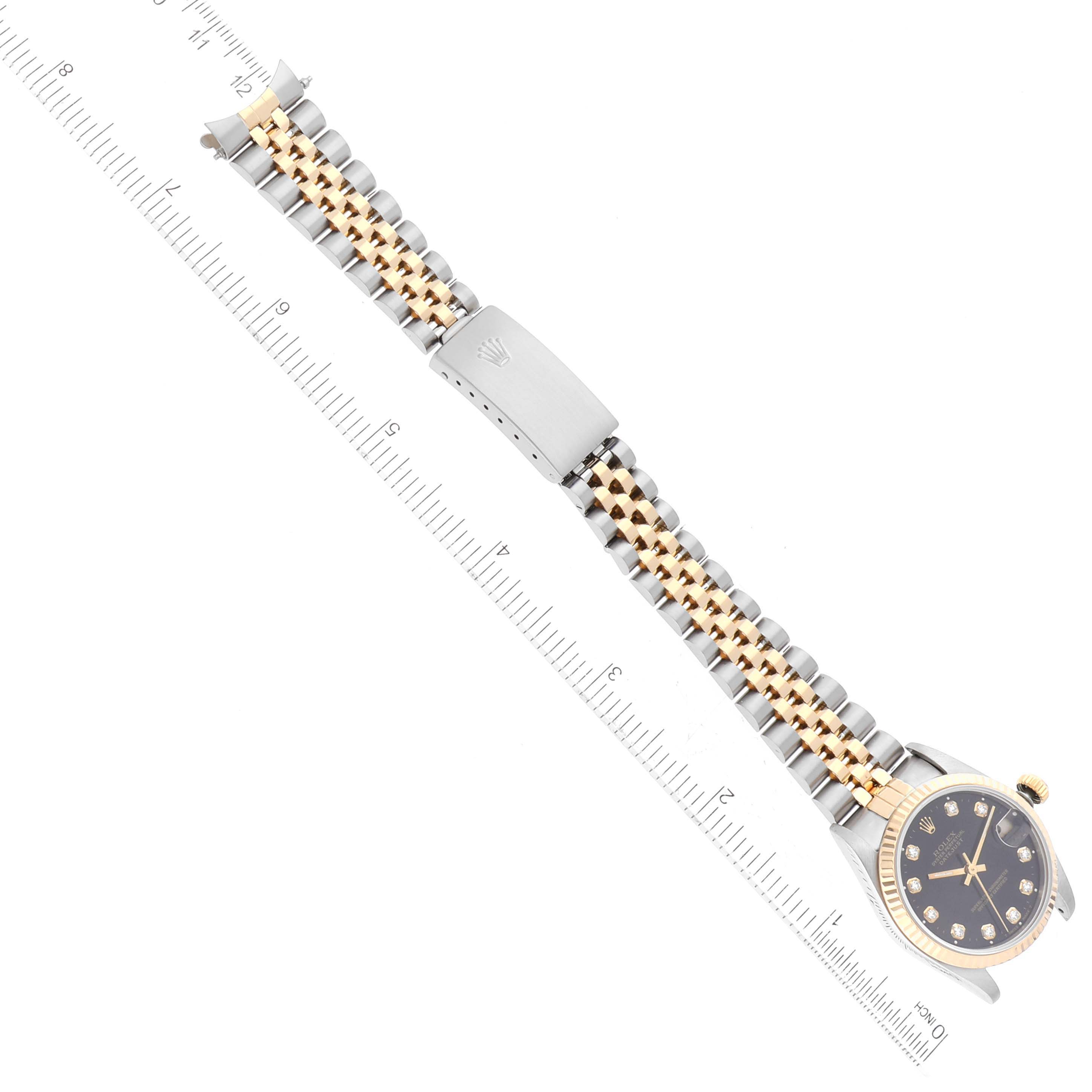 The Rolex Mid-Size 68273 Women's Steel and Gold (two tone) Black Dial 68273 Women's Steel and Gold (two tone) Black Dial model is shown flat with a close-up of the face, bezel, and bracelet next to a ruler for scale.