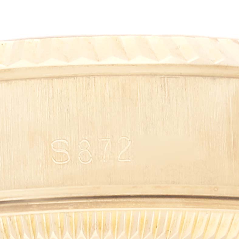 This image shows a close-up of the side of a Rolex President 69178G Women's Yellow Gold Champagne Dial 69178G Women's Yellow Gold Champagne Dial model watch, highlighting the bezel and an engraved serial number.