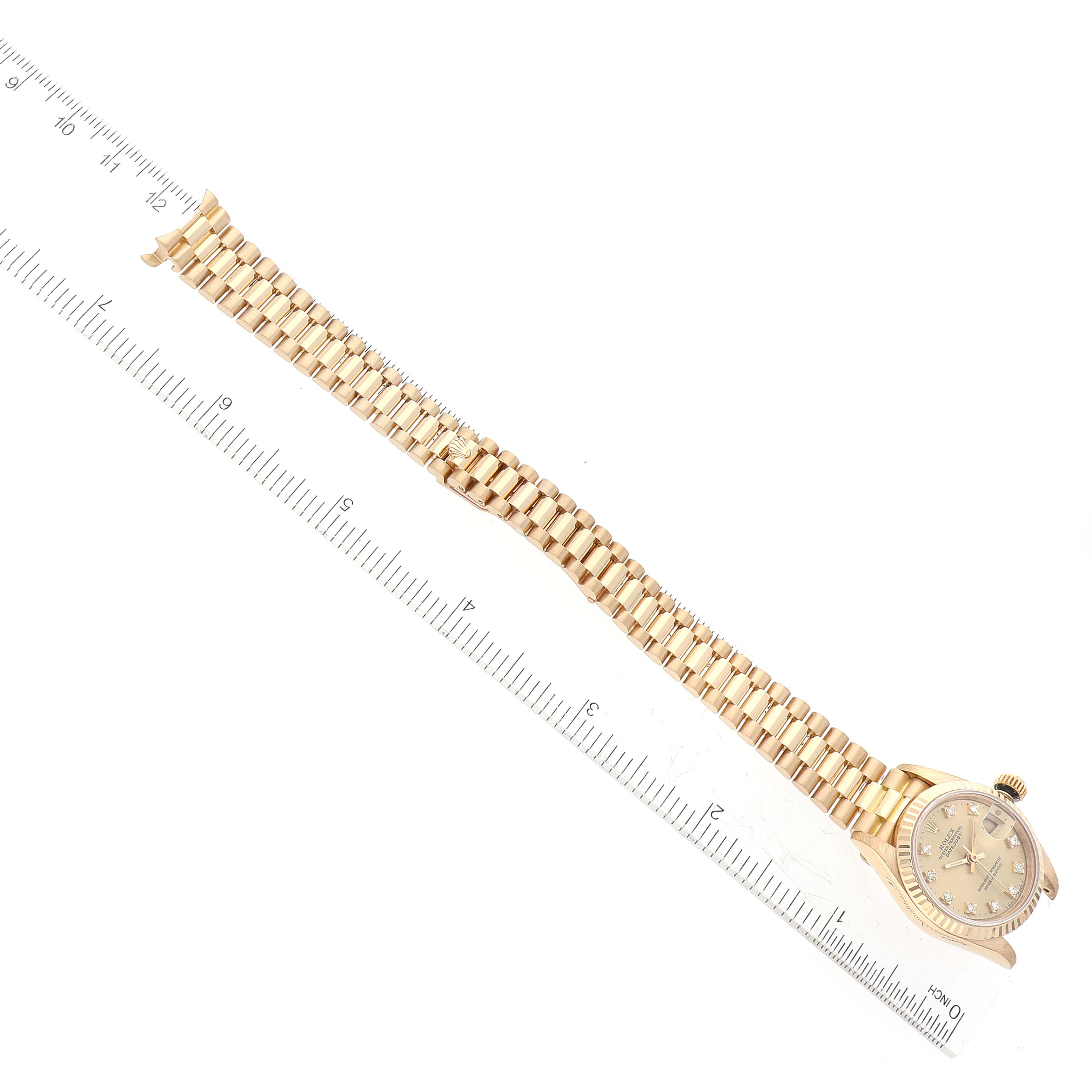 The image shows a Rolex President 69178G Women's Yellow Gold Champagne Dial 69178G Women's Yellow Gold Champagne Dial watch laid flat with its face and full bracelet visible, next to a ruler for scale.