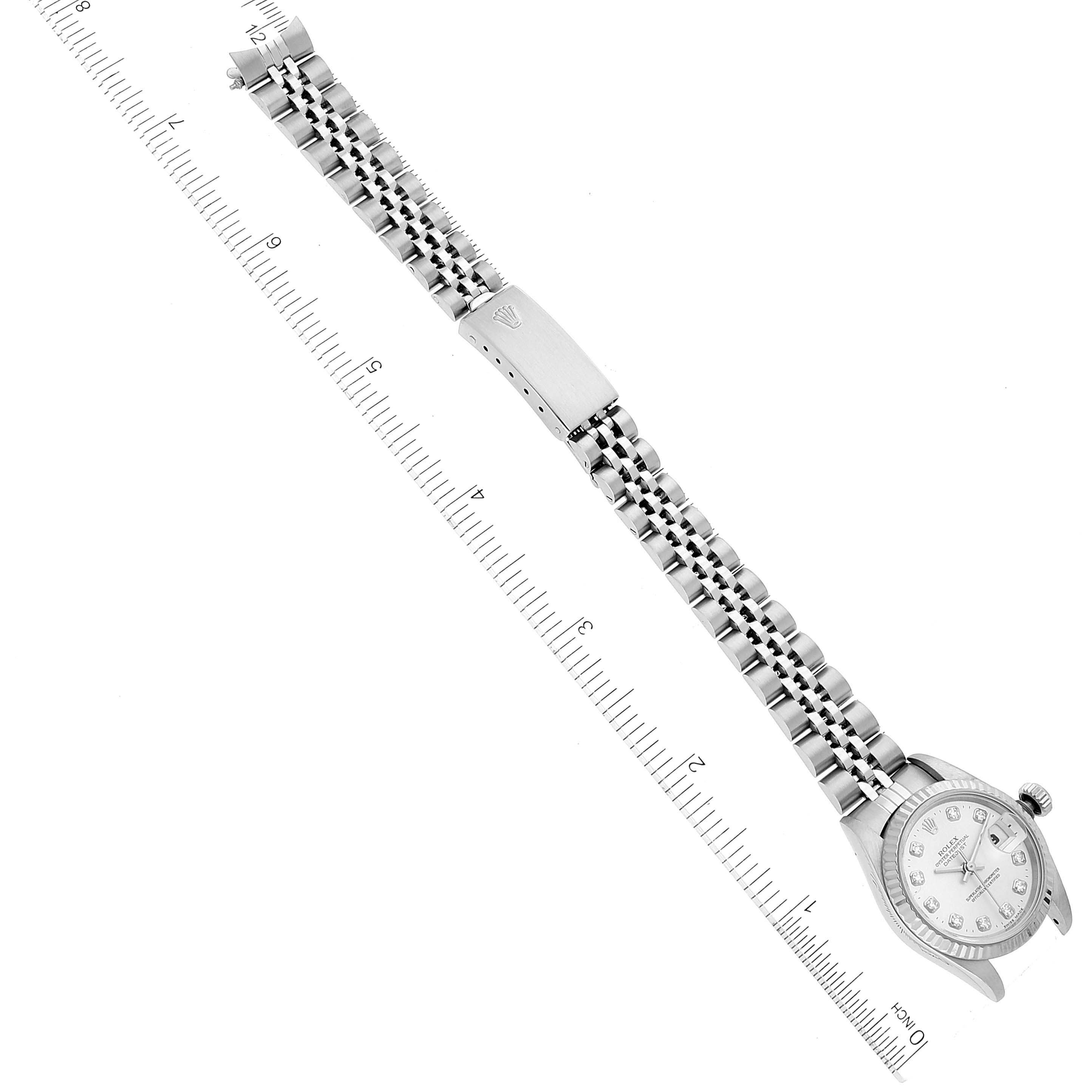 This image shows a Rolex Datejust 69174 Women's Stainless Steel Silver Dial 69174 Women's Stainless Steel Silver Dial watch laid flat with the face and steel bracelet clearly visible against a ruler for scale.