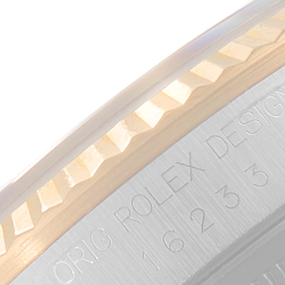 This image shows a close-up of the fluted bezel and part of the casing with engraved text of a Rolex Datejust 16233 Men's Steel and Gold (two tone) Black Dial 16233 Men's Steel and Gold (two tone) Black Dial watch.