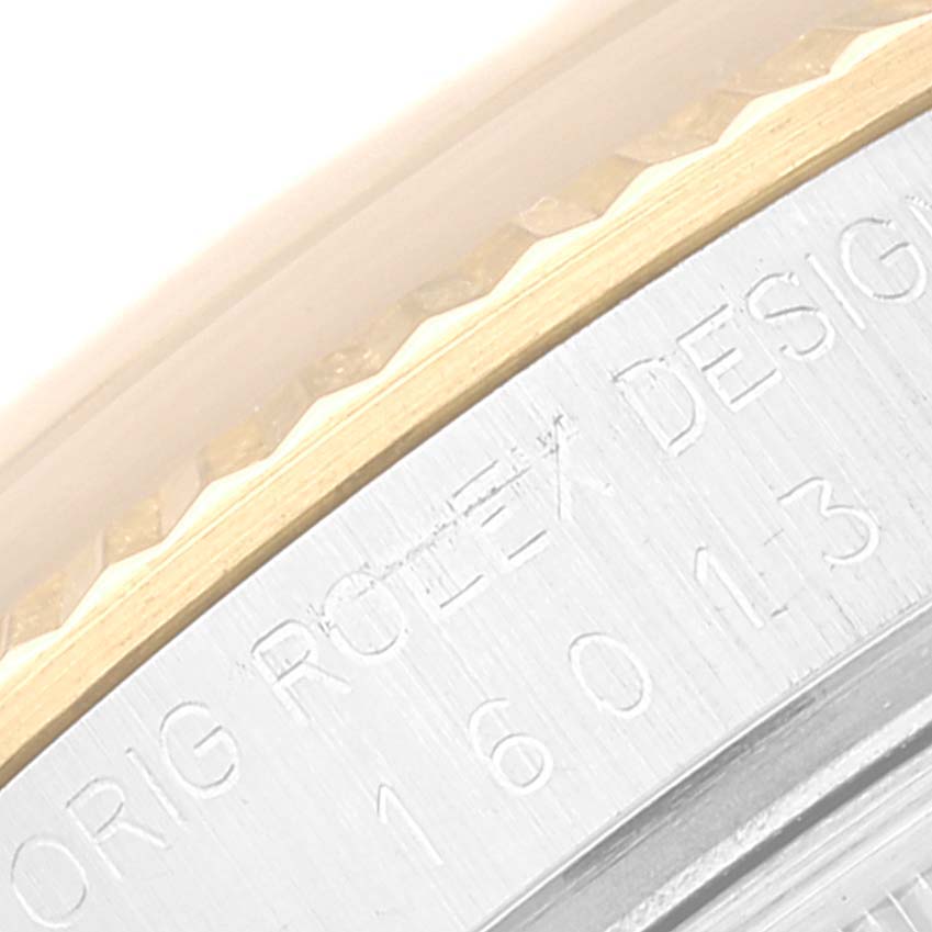 The image shows a close-up of the bezel and case edge, featuring engraved text, of a Rolex Datejust 16013 Men's Steel and Gold (two tone) White Dial 16013 Men's Steel and Gold (two tone) White Dial watch.