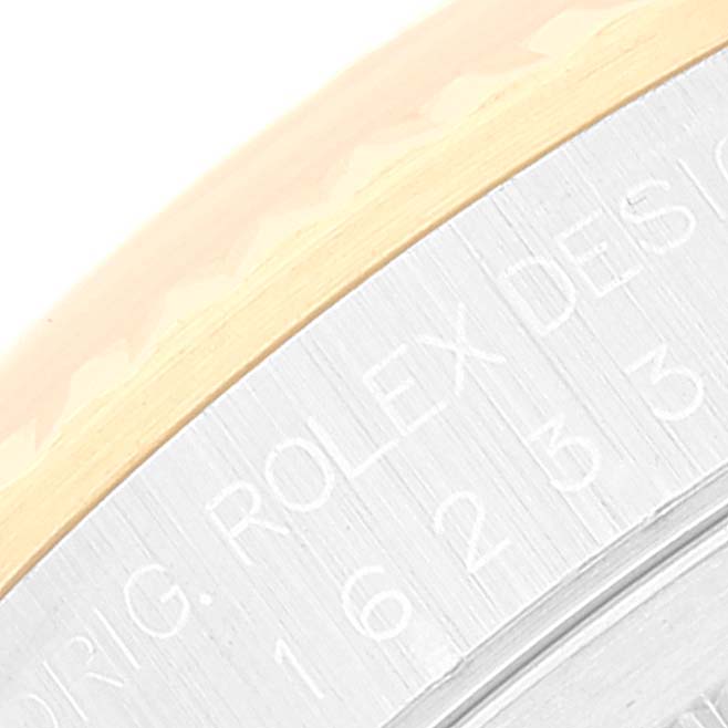 The image shows a close-up of the engravings on the edge of the bezel and case-back of the Rolex Datejust 16233 Men's Steel and Gold (two tone) Champagne Dial 16233 Men's Steel and Gold (two tone) Champagne Dial.