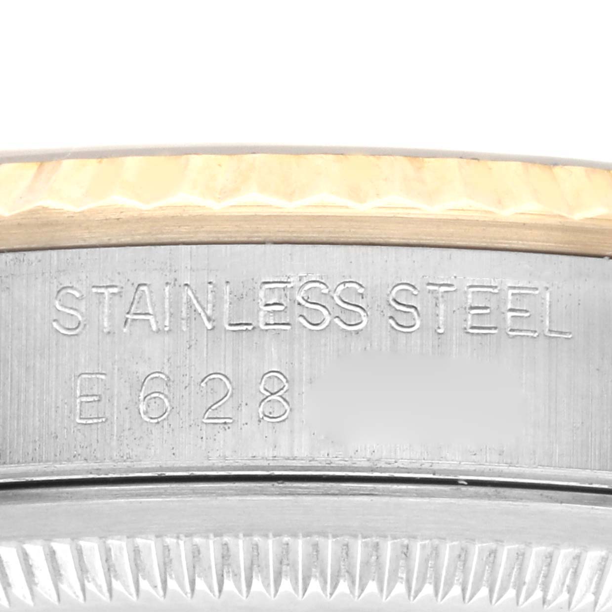 The image shows a close-up of the Rolex Datejust 16233 Men
s Steel and Gold (two tone) Champagne Dial 16233 Men
s Steel and Gold (two tone) Champagne Dial
s case edge, revealing "STAINLESS STEEL" engraving and part of the fluted bezel.