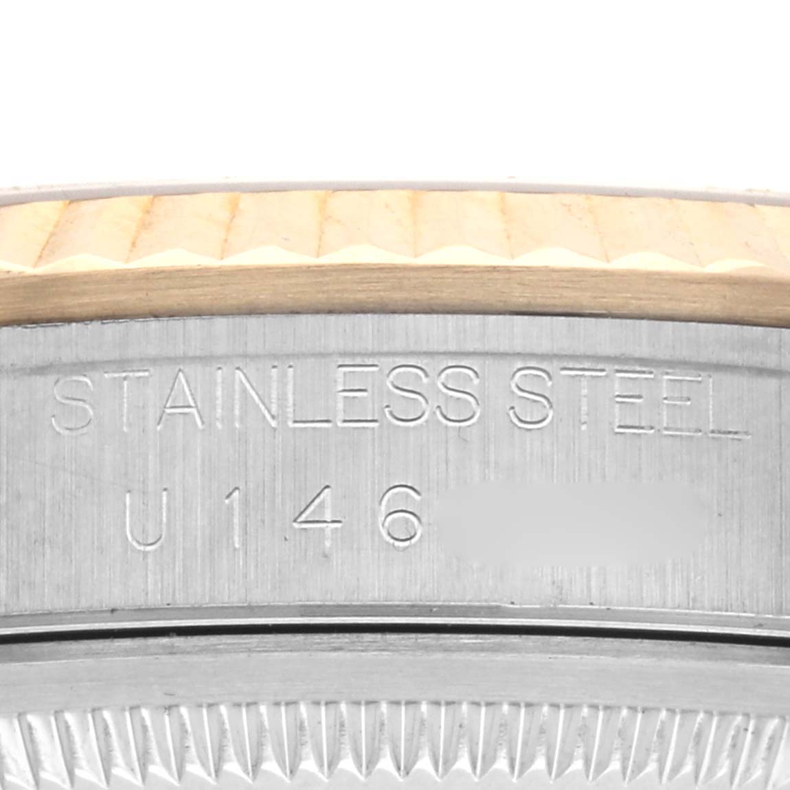 The image shows a close-up of the side of a Rolex Datejust 16233 Men's Steel and Gold (two tone) Champagne Dial 16233 Men's Steel and Gold (two tone) Champagne Dial, featuring engraved text and the fluted bezel.