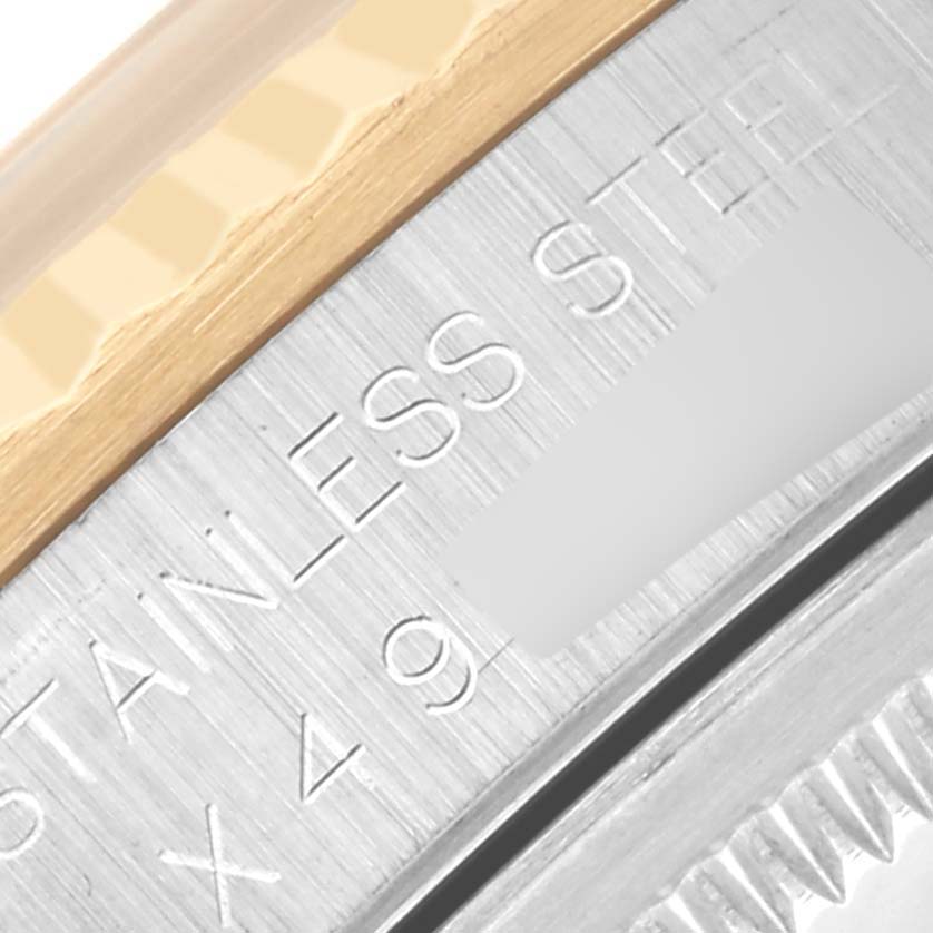 The image shows a close-up of the Rolex Datejust 16233 Men's Steel and Gold (two tone) Champagne Dial 16233 Men's Steel and Gold (two tone) Champagne Dial's beveled stainless steel and gold-capped edge.