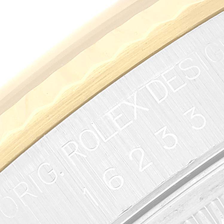 This close-up image of the Rolex Datejust 16233 Men's Steel and Gold (two tone) Champagne Dial 16233 Men's Steel and Gold (two tone) Champagne Dial watch shows part of its case edge and engraved text.